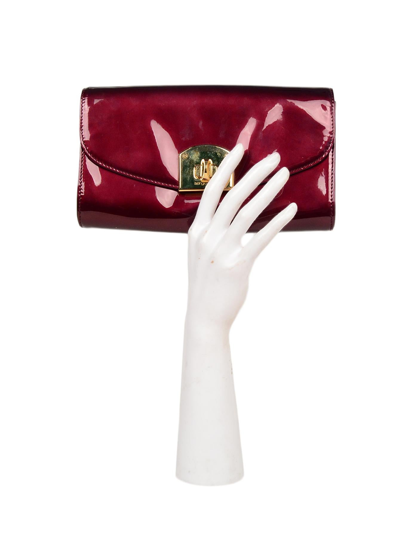 Sergio Rossi Burgundy Patent Leather Clutch W/ Wrist Strap

Made In: Italy
Color: Burgundy, gold
Hardware: Goldtone
Materials: Patent leather, metal
Lining: Tan leather
Closure/Opening: Flap top with twistlock closure 
Exterior Pockets:
