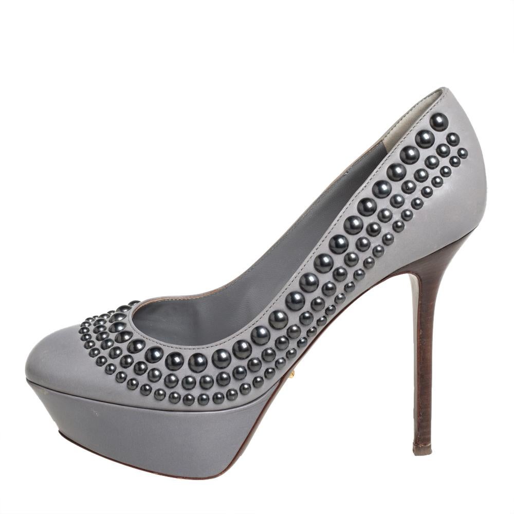 These Sergio Rossi pumps are the epitome of class, luxury, and style. Crafted from leather in a grey shade, they are detailed with differently-sized studs then elevated on 12 cm stiletto heels supported by platforms.

