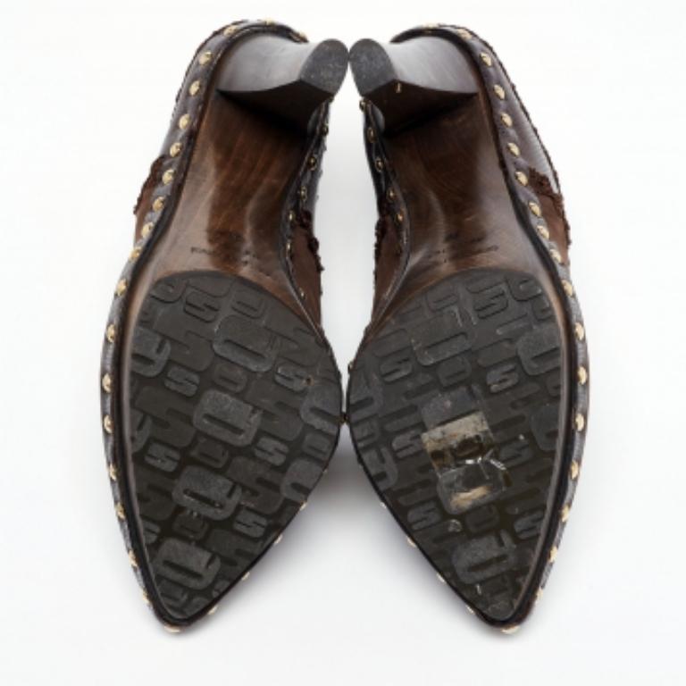 Make a bold style statement as you flaunt these Sergio Rossi mules. They come crafted from brown, lizard-embossed leather and suede and feature a pointed-toe silhouette. They have been designed with studs and open backs and are endowed with