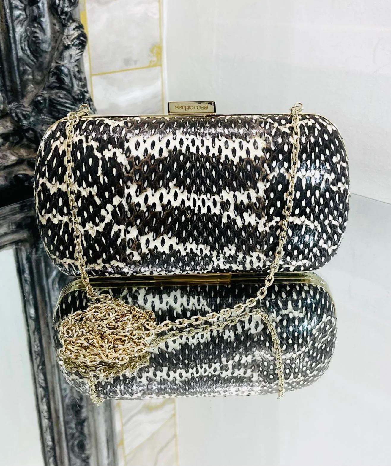 Sergio Rossi Lizard Skin Clutch Bag With Chain

Hard case bag in black and white exotic skin, gold hardware and chain strap. Logo engraved closure.

Additional information:
Size – 20 W x 5 D x 10 H cm
Composition – Lizard Skin 
Condition – Very