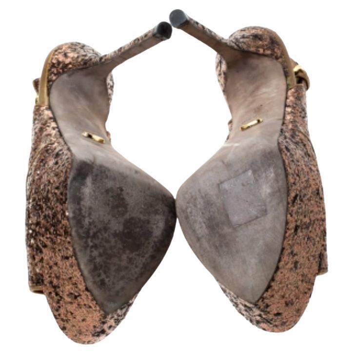 Kühn, glamourös und sehr stilvoll, diese Sandalen von Sergio Rossi haben die Macht, die Massen zu verzaubern. Diese Sandalen aus goldfarbenem Metallic-Glitter haben eine Peep-Toe-Silhouette und zeigen sich mit geschnallten Slingbacks. Sie sind mit