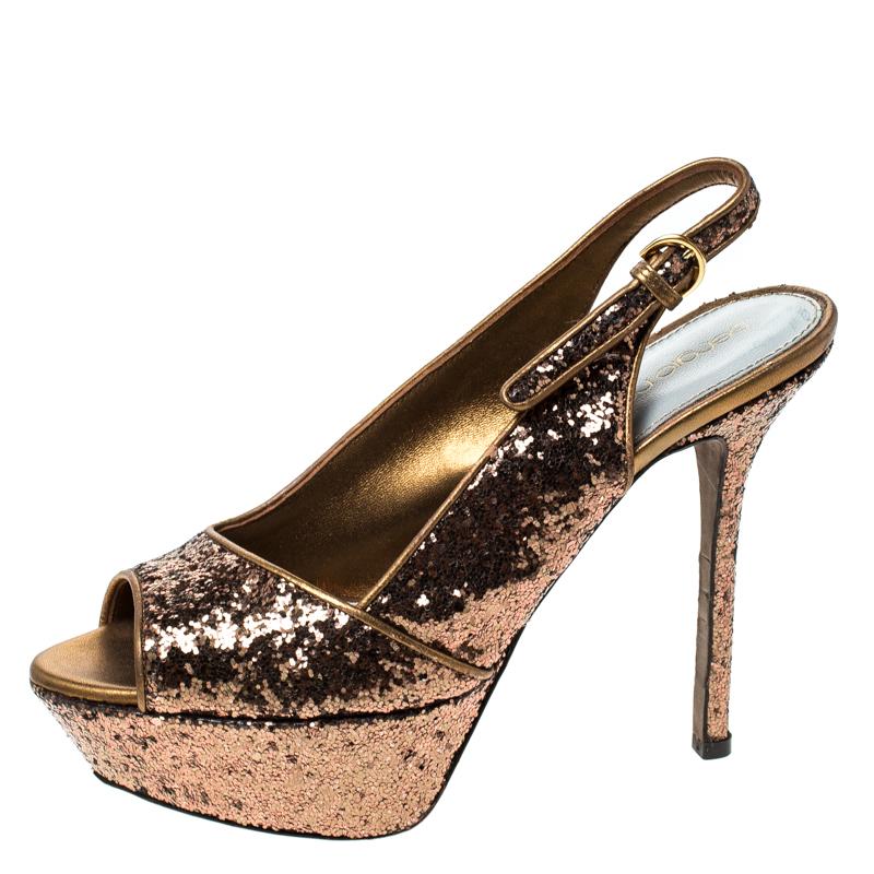 Bold, glamorous and very stylish, these sandals from Sergio Rossi have the power to enchant the crowds. Crafted from metallic gold glitter, these sandals feature a peep-toe silhouette and flaunt buckled slingbacks. They come equipped with 12 cm