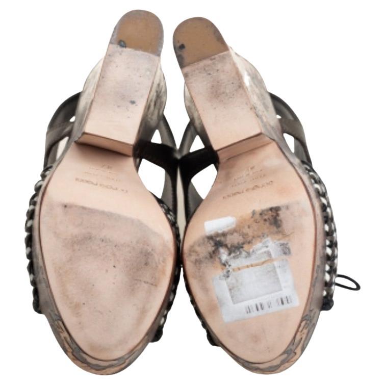 These Sergio Rossi sandals feature a leather upper beautifully complemented by patterns on the platforms and heels. The open-toe sandals are secured with lace-up ties.