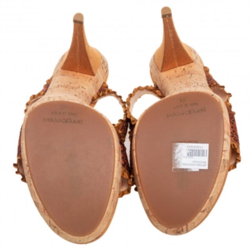 Grant your feet with never-ending style and panache as you wear these slide sandals from the House of Sergio Rossi. Their upper features dual bow motifs, which are made from mustard brown embroidered fabric. To add to their beauty, they are accented