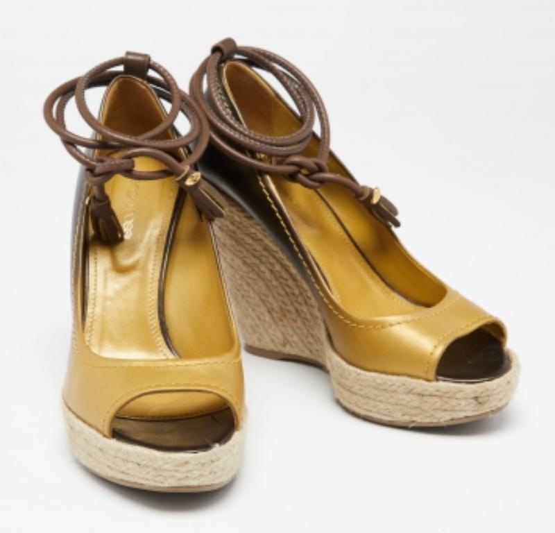 These pumps from the House of Sergio Rossi are designed to bring comfort and style at the same time. They are made from ombre gold leather and added with peep toes, ankle ties, and wedge heels.