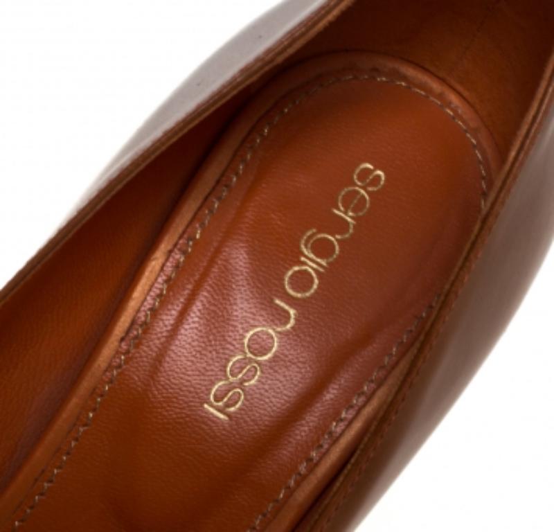 Project an elegant take in a comfortable manner with these pumps by Sergio Rossi. Crafted from orange and brown leather, they feature peep toes and 11.5 cm heels supported by platforms.