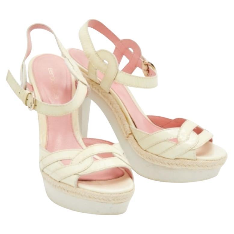 Pamper your feet with these Sergio Rossi sandals. Created from patent leather, they exhibit intertwined straps on the vamps, an ankle buckle closure, and espadrille trims. The 12.5cm heels and platforms of this pair will lend you the perfect height
