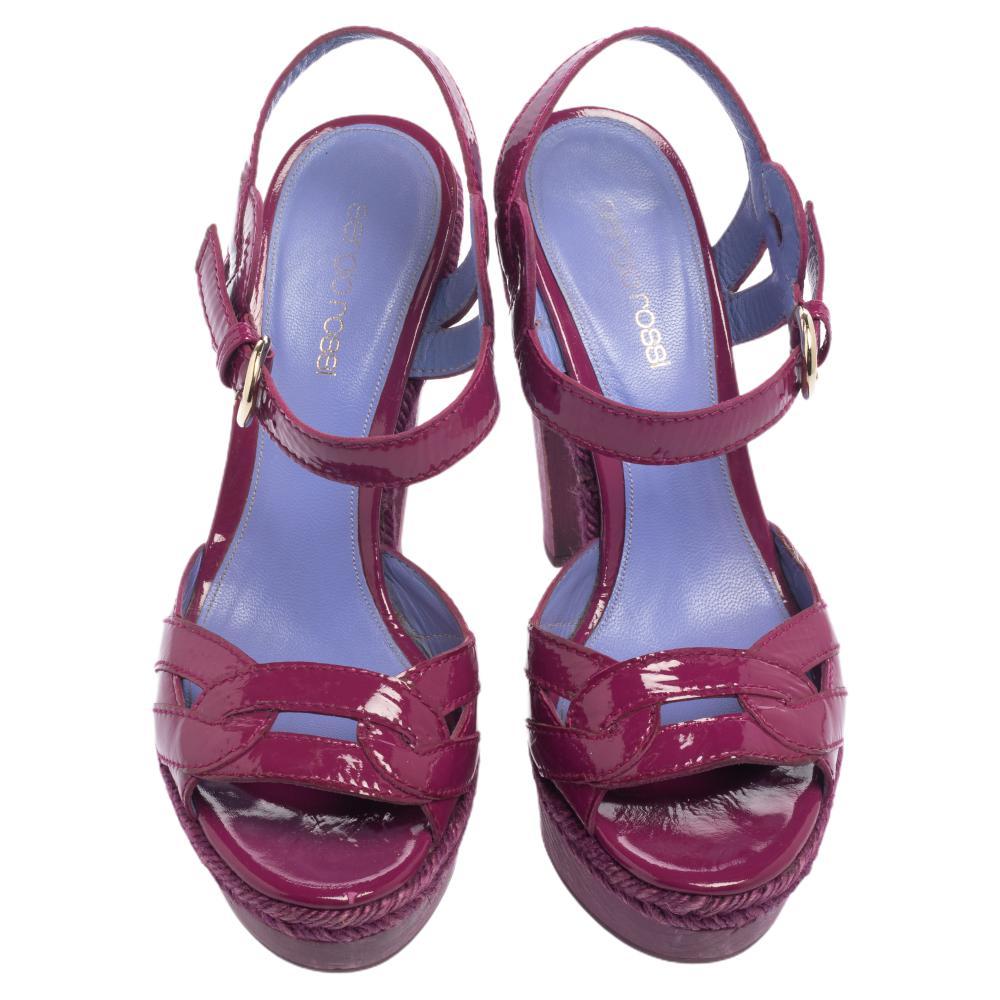 Amp up your style quotient as you glam up your casual outfit with these gorgeous sandals from Sergio Rossi. These purple patent leather sandals are styled with open toes, buckled ankle straps, wooden platforms and 13 cm heels.

Includes: Original