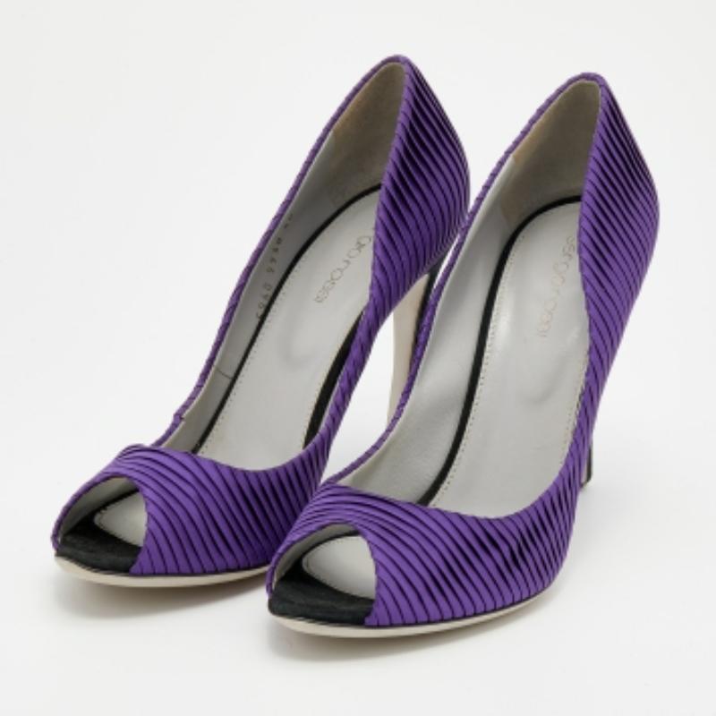 Sfoggia un look elegante in modo confortevole con queste intramontabili décolleté di Sergio Rossi. Realizzate in Italia in raso nella tonalità del viola, hanno la punta aperta, le pieghe e il tacco di 11 cm.