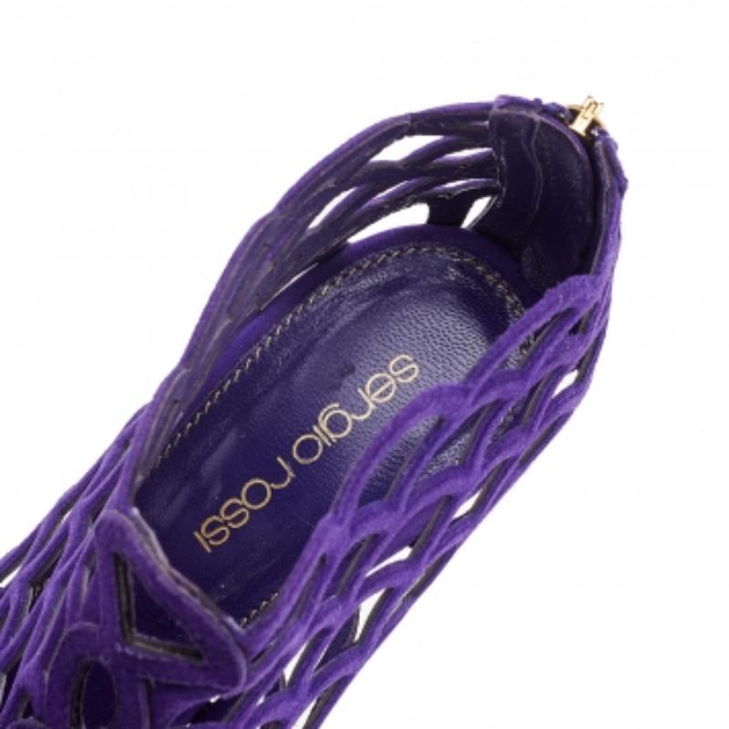 Frame your feet with these booties from Sergio Rossi! The pair comes made with purple-colored suede on the exterior and is secured by zippers on the counters. Peep-toes, stiletto heels, and scalloped cage design add beauty to the shoes. Perfect for