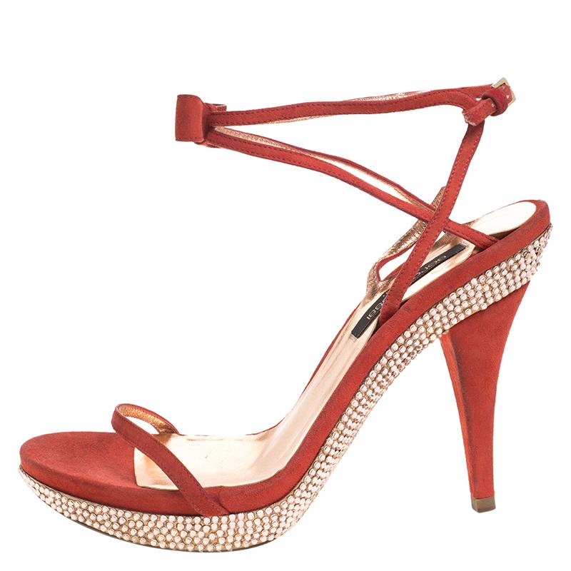 Flaunt these fabulous sandals from Sergio Rossi as step out in style. This gorgeous pair of sandals made of suede has crystal embellishments on the platforms as well as the outsoles. They are equipped with high heels and ankle straps. A pair of