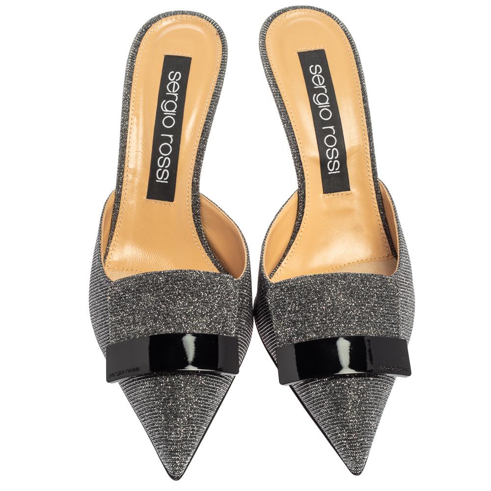 These mules from Sergio Rossi are chic and contemporary! They come crafted from glitter fabric and feature an eye-pleasing combination of silver and black hues. They have been styled with pointed toes. Comfortable leather lined insoles and 8.5 cm