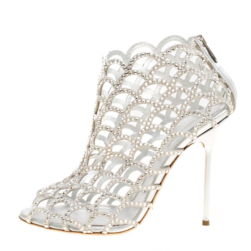 Exquisite, enchanting and very stylish, these booties from Sergio Rossi will make your heart skip a beat! The silver booties are crafted from suede and feature a peep-toe silhouette. They flaunt a scalloped caged design with straps that are adorned