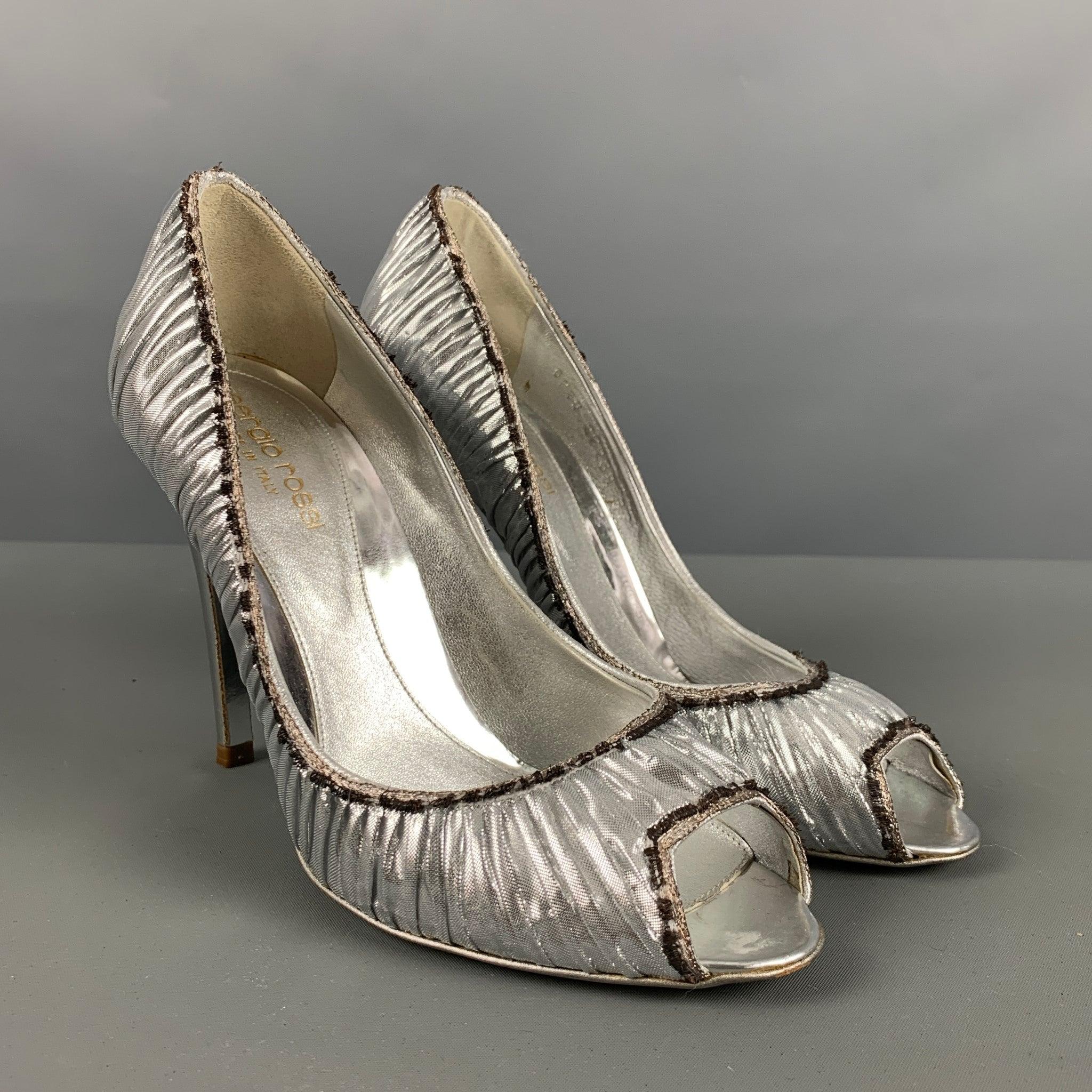 SERGIO ROSSI pumps comes in a silver metallic lame material featuring an open toe style and a silver metallic heel. Made in Italy.Very Good Pre-Owned Condition. Minor signs of wear. 

Marked:  
5756 27289 37 

Measurements: 
  Heel: 4.25 inches 
  
