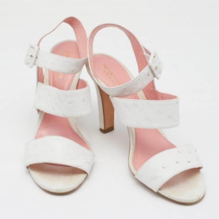 Diese Sandalen von Sergio Rossi umrahmen mit ihren breiten Riemen Ihre Füße und sind mühelos schick. Sie sind aus Straußenleder gefertigt und verfügen über einen Schnallenverschluss am Knöchel, einen 9,5 cm hohen Absatz und goldfarbene Beschläge.