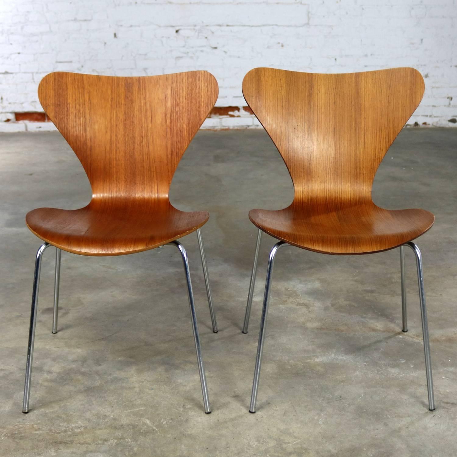 Pair of vintage MCM Series 7 Model 3107 molded teak chairs with chrome legs designed by Arne Jacobsen for Fritz Hansen in 1955. This pair is in wonderful vintage condition with age appropriate wear. One chair retains its original plastic bowl shaped