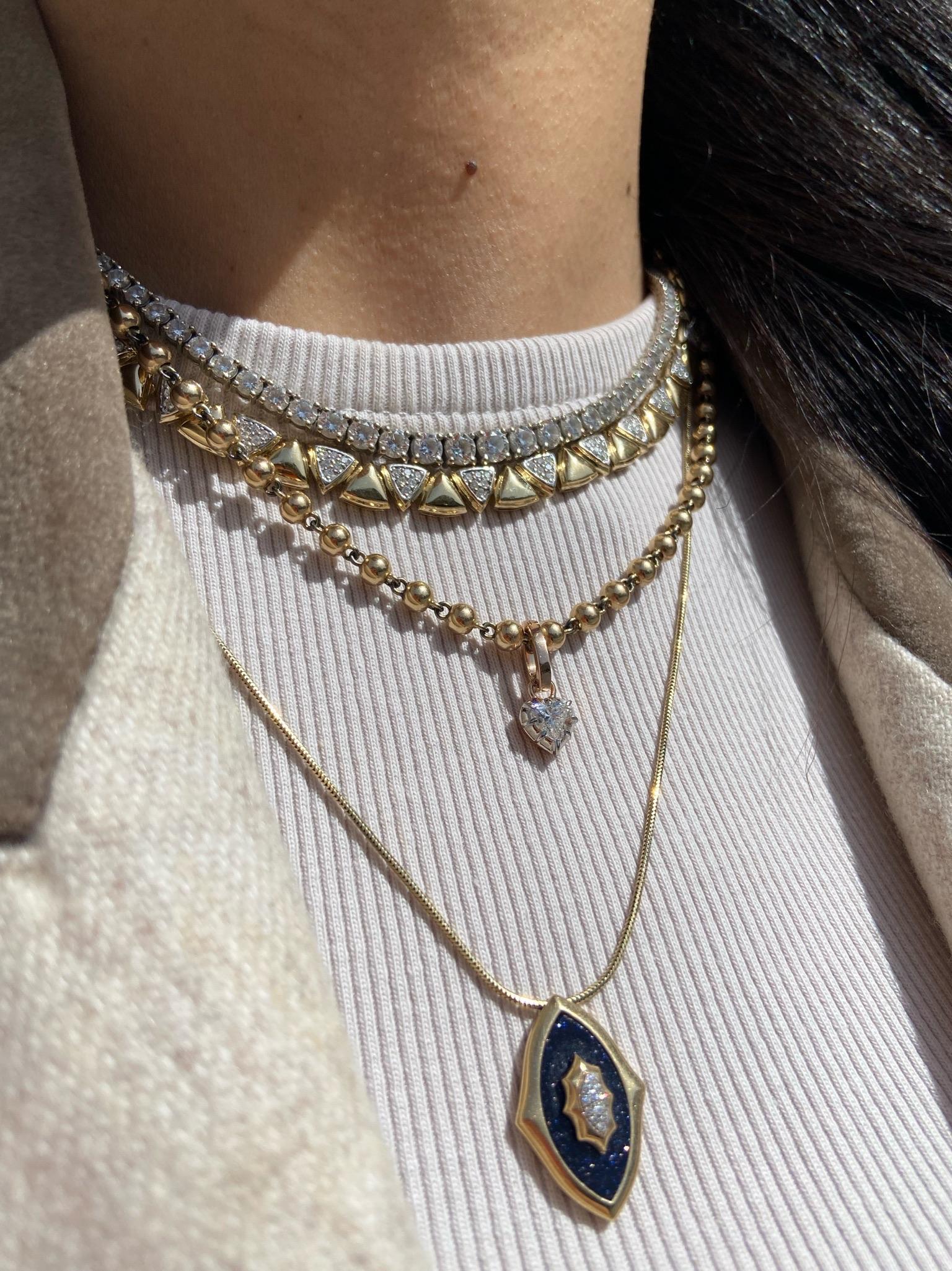 Bold yet refined, this unique necklace showcases a series of polished yellow gold triangular links, each alternating with pavé-set diamond triangles for a striking geometric pattern. Modern and sophisticated, it’s a standout piece that brings