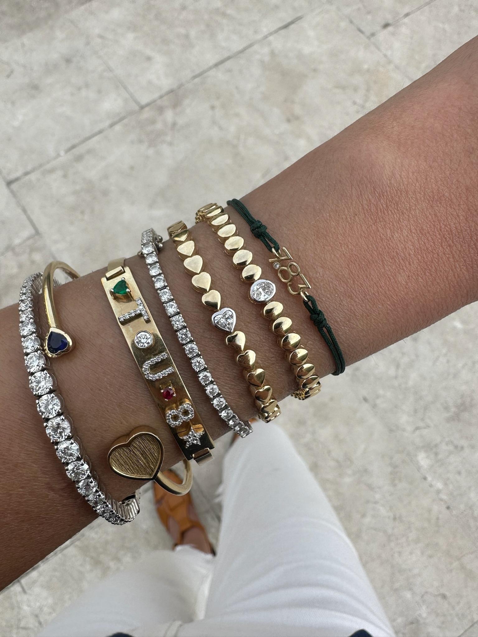 This elegant bracelet features a continuous strand of polished, oval-shaped yellow gold links, exuding understated sophistication. At its center, a single bezel-set oval diamond in white gold adds a refined focal point, creating a subtle yet