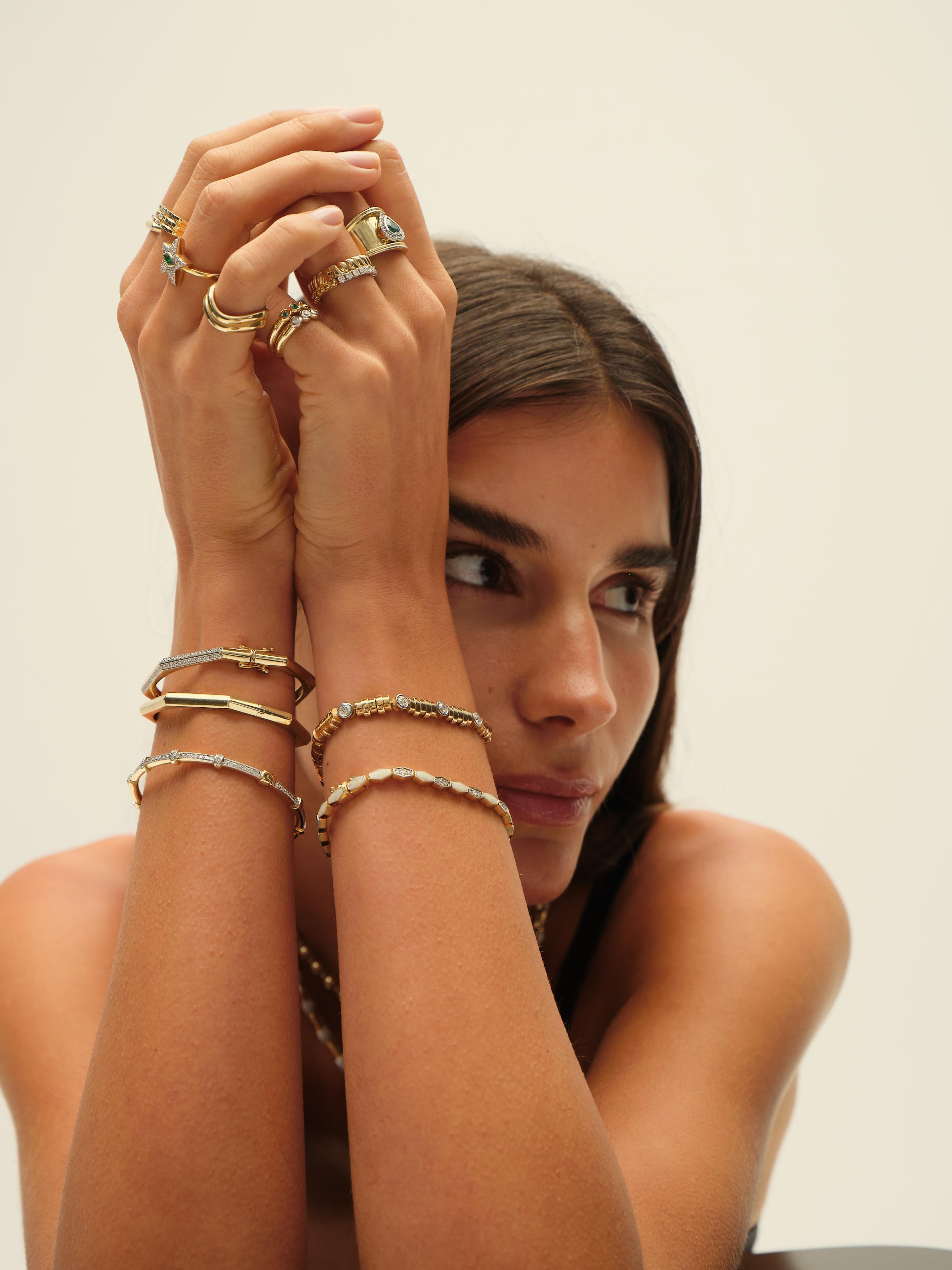 This bracelet exudes modern luxury with its bold design, featuring alternating polished and satin-finish yellow gold links. Round bezel-set diamonds are evenly spaced across the front, adding brilliance and visual rhythm to the piece. The bracelet