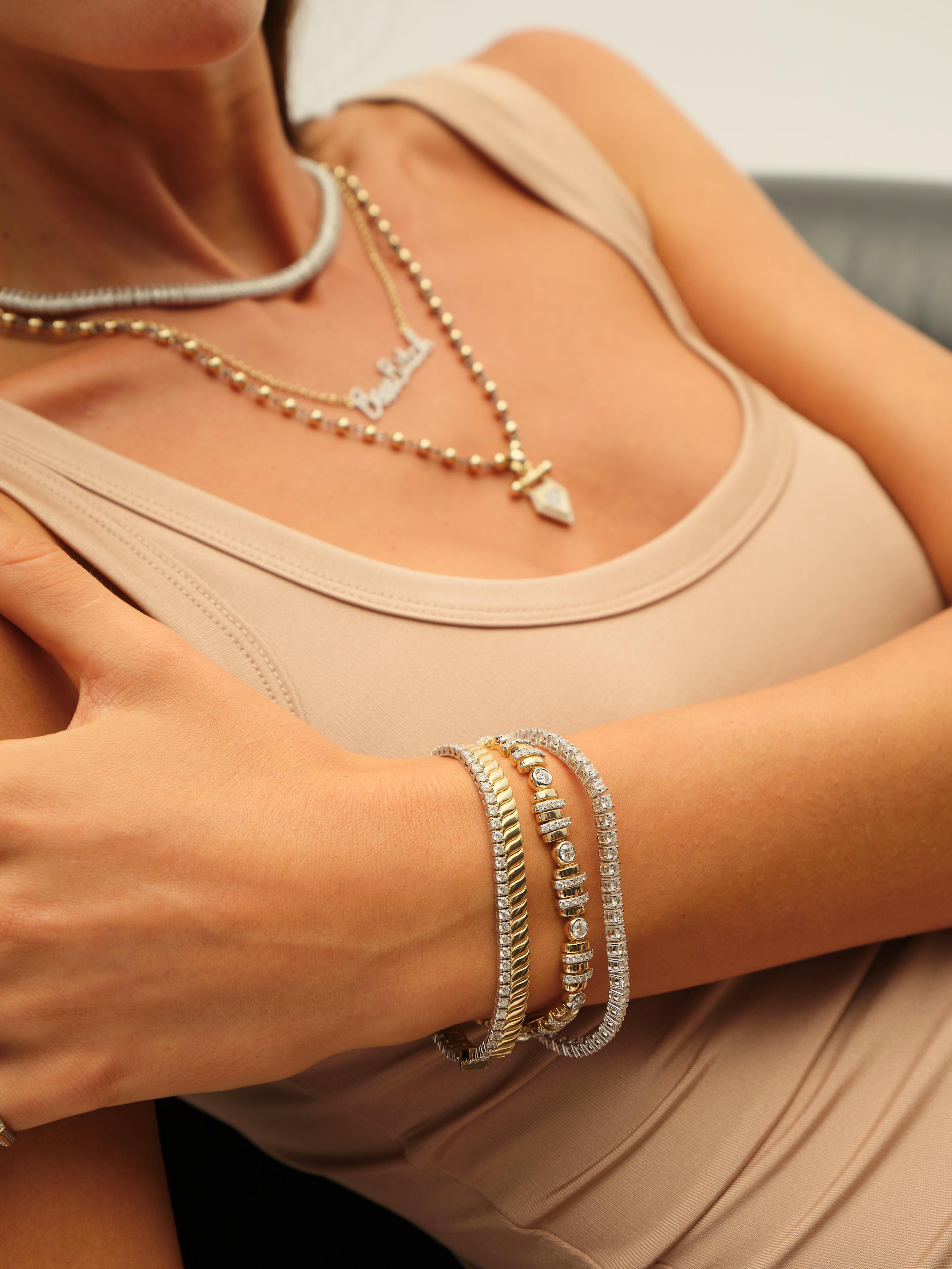 This luxurious bracelet combines classic elegance with contemporary design, featuring alternating sections of round bezel-set diamonds and yellow gold links framed by pavé-set white gold bands. The repeating pattern creates a stunning visual rhythm,