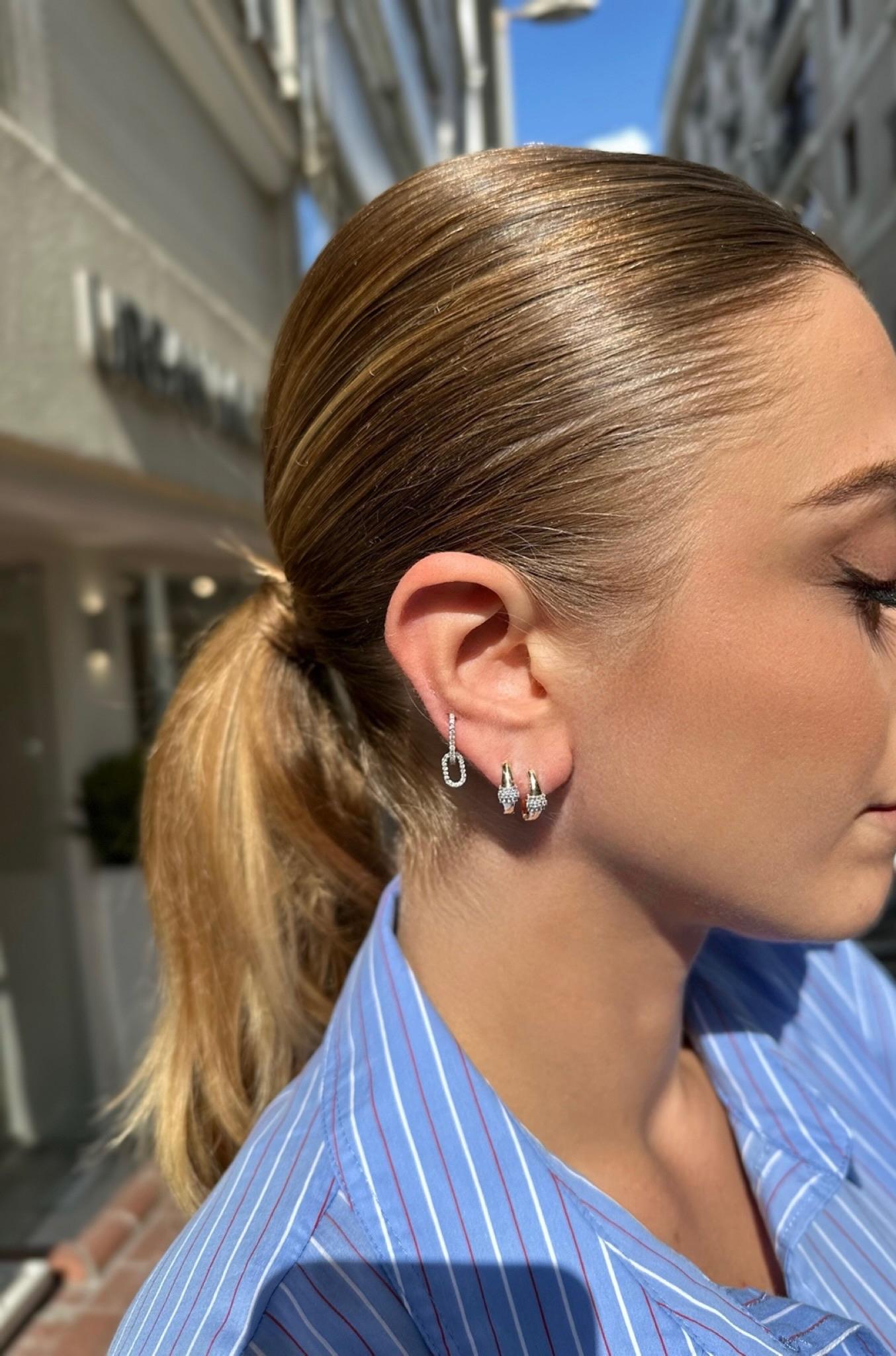 Diese zeitlosen und raffinierten Ohrringe aus 14-karätigem Gold sind mit drei Reihen von Diamanten im Brillantschliff verziert, die das Zentrum in strahlendem Glanz erstrahlen lassen. Das skulpturale Golddesign rahmt jeden Stein elegant ein und