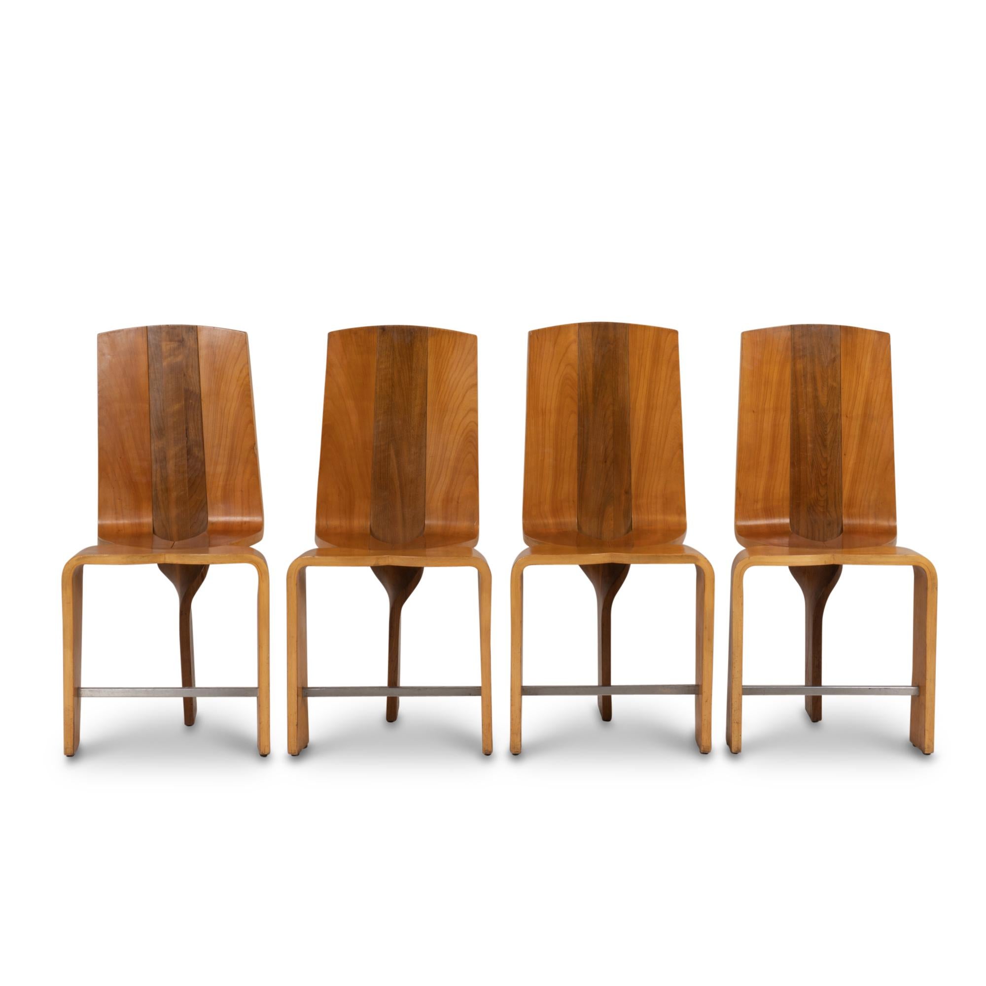 Series of eight blond cherry wood chairs. Tripod base. Face of the base joined by a spacer bar, base of the back of wavy and abstract shape.

Work realized in the 1980s.