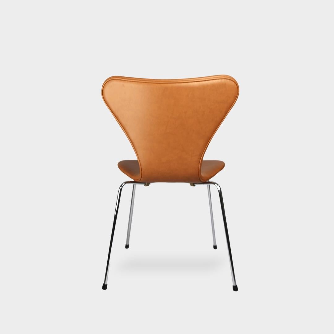 Arne Jacobsen Series 7 Chairs in Calvados Cognac Leather: Beautifully reupholstered in soft Calvados leather and fitted with new foam padding. These chairs feature a firm backrest and are free from any defects. They are original pieces manufactured