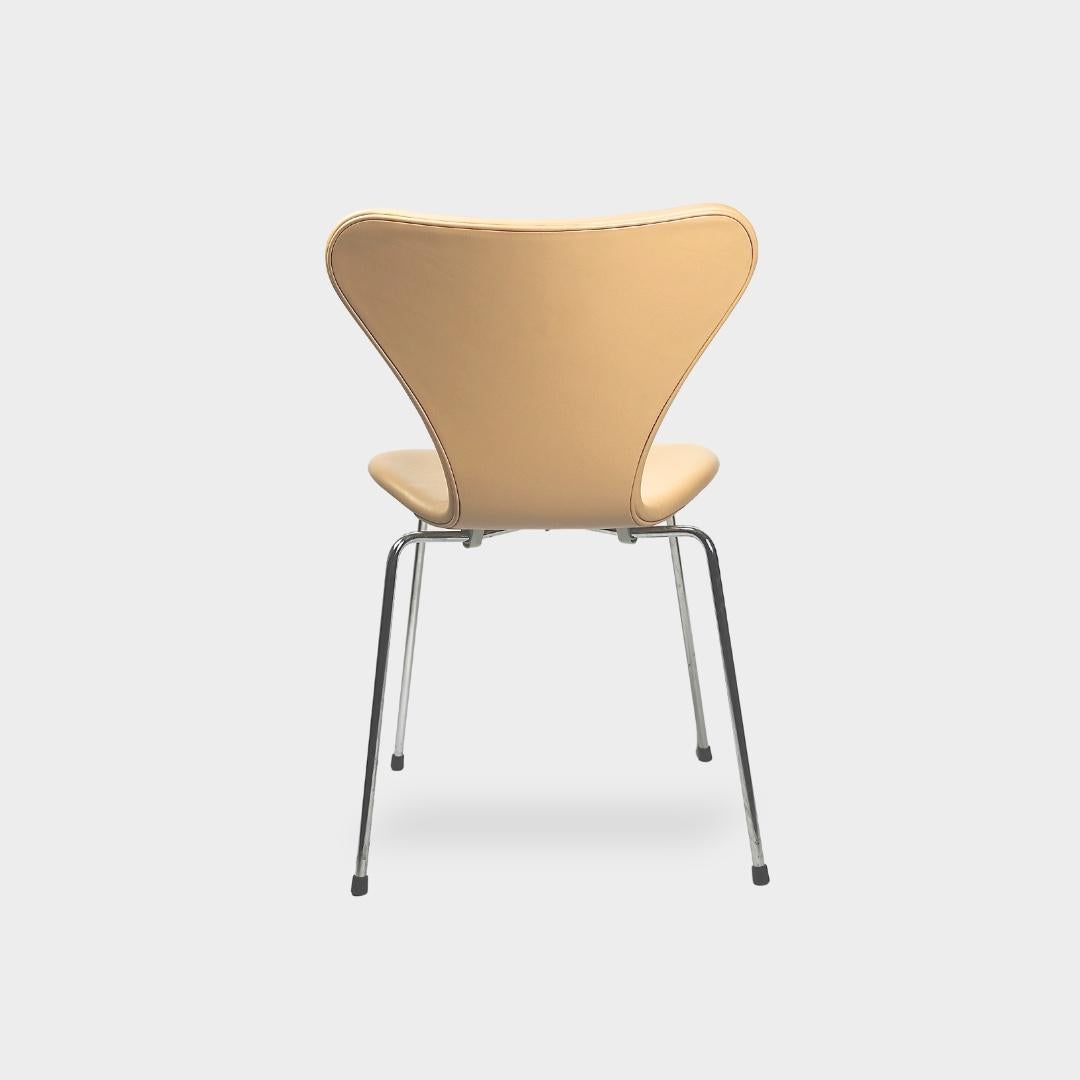 Arne Jacobsen Serie 7 Stühle in Sand Semi-Anilin Leder und mit dem satinierten Gestell Look. Wunderschön neu gepolstert in weichem Schwarz und mit neuen Schaumstoffpolstern ausgestattet. Diese Stühle haben eine feste Rückenlehne und sind frei von