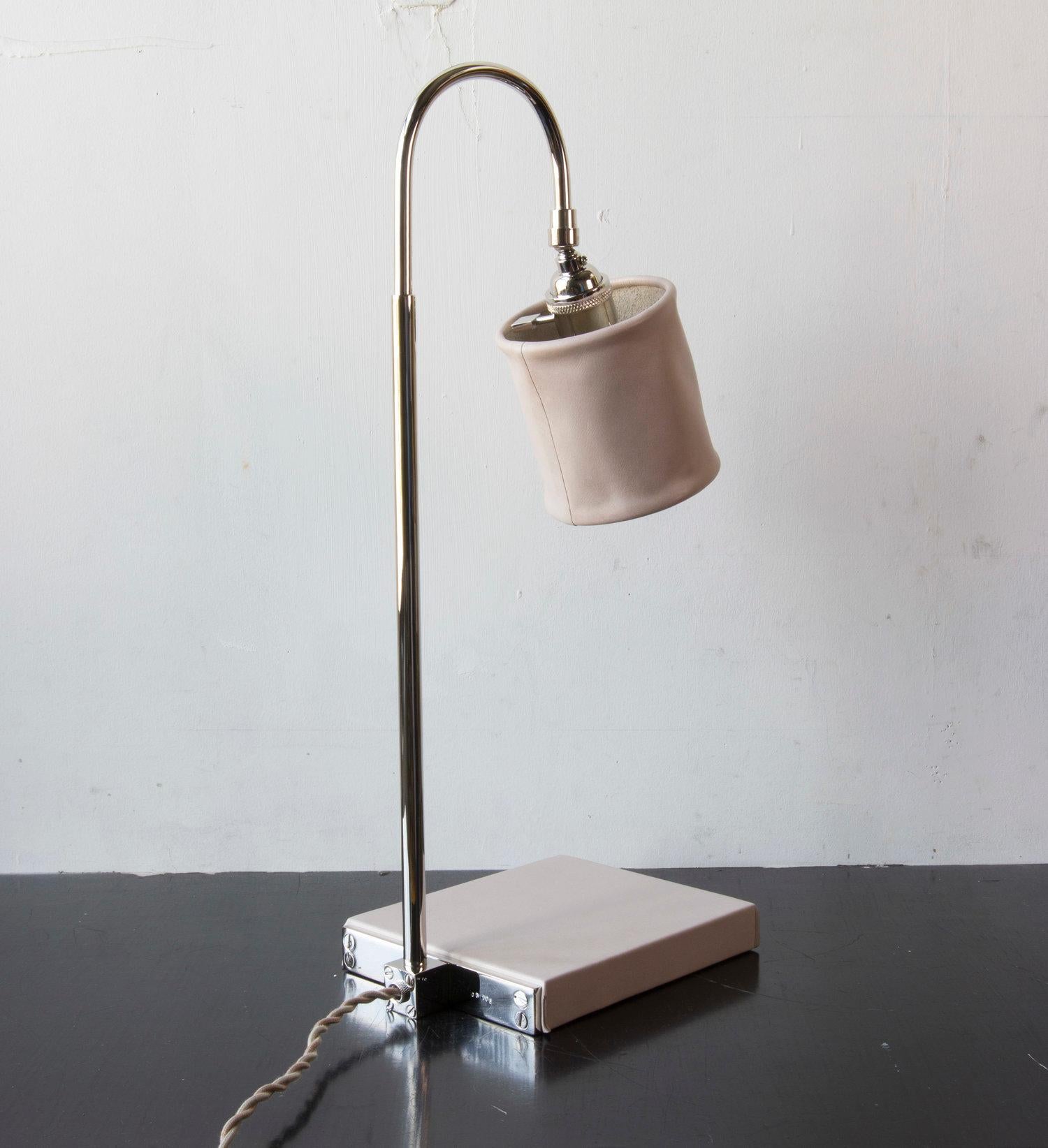 Solid machined brass in polished nickel-plated finish, hand-dyed and waxed leather wrapped wood, soft unstructured pivoting leather shade, hand-dyed braided cotton cord. All material finishes are living finishes: they will change and patina for the