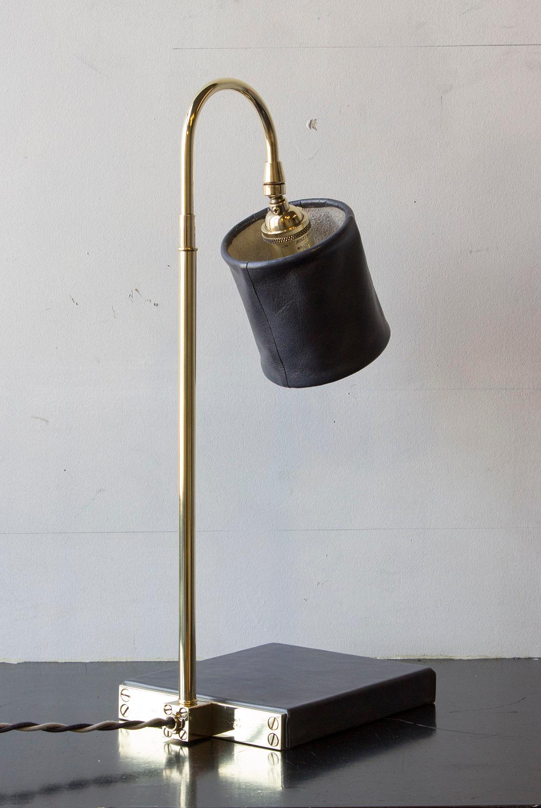 Solid machined brass in polished unlacquered finish, hand-dyed and waxed leather wrapped wood, soft unstructured pivoting leather shade, hand-dyed braided cotton cord. All material finishes are living finishes: they will change and patina for the