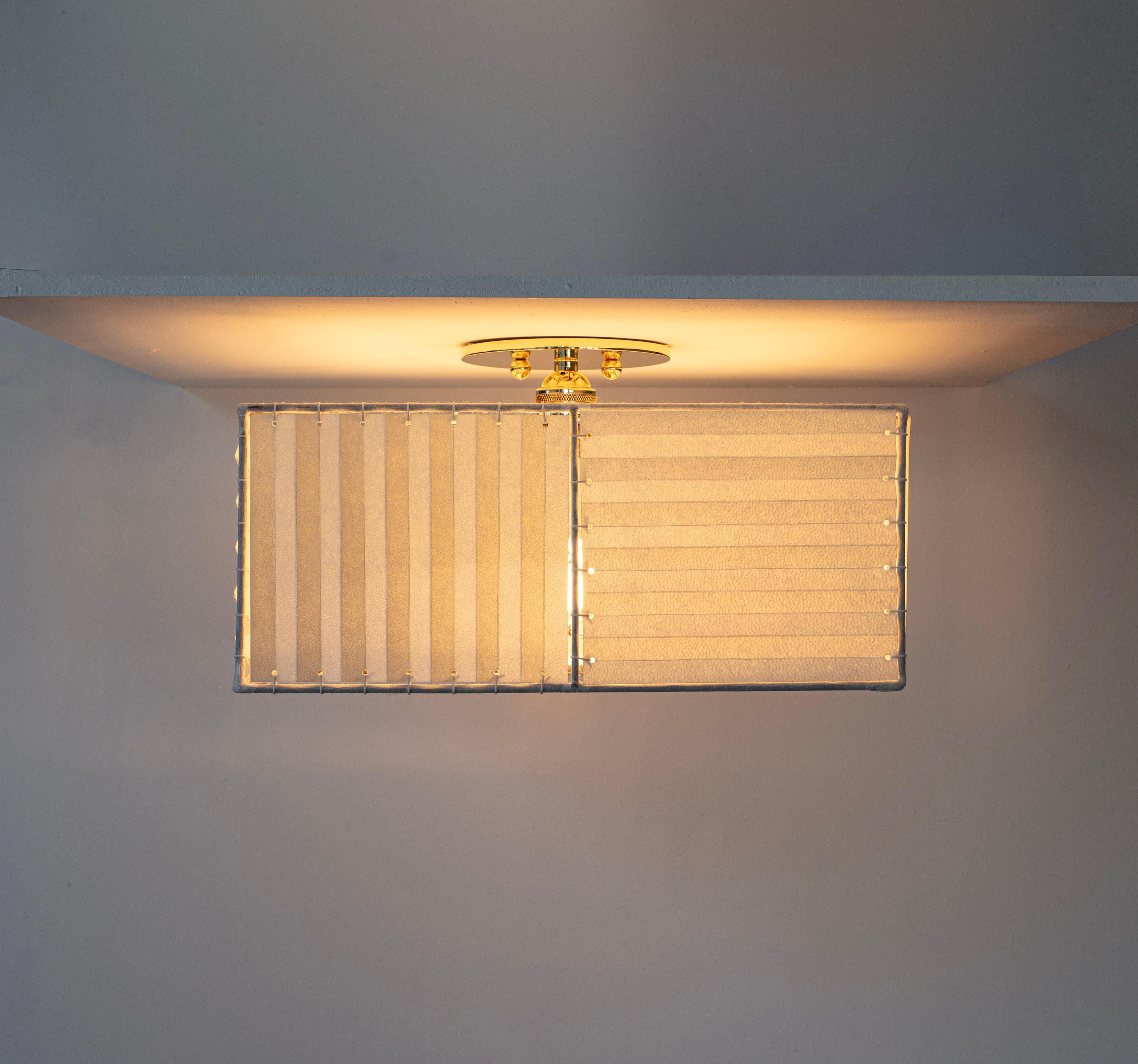 Solid machined brass, hand-stitched accordian folded goatskin parchment shade with diffuser. 

Shades are made from genuine goatskin parchment, hand-selected for each lamp for its natural texture, pattern and color. Reminiscent of the lunar surface,
