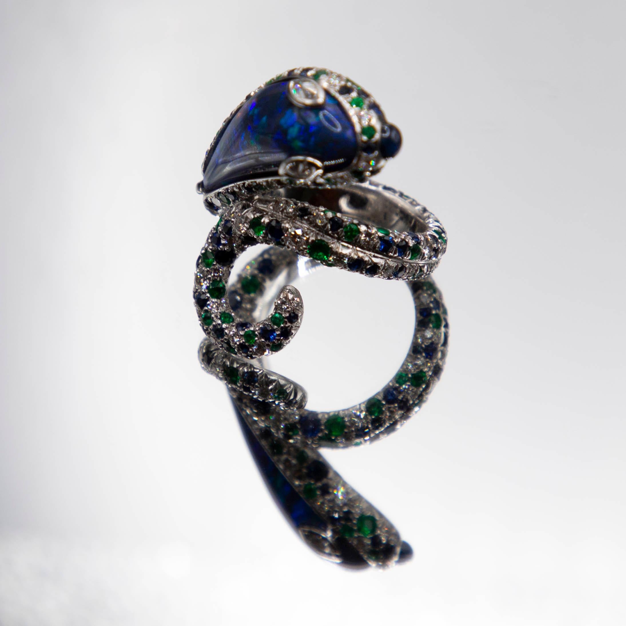 A one of a kind handmade serpent ring features one of the world's finest Black Opals from Lightning Ridge Australia, weighing 7.61 carats. The gem, an exceedingly rare blue/black, was hand carved to an exquisite flowing form which evolved