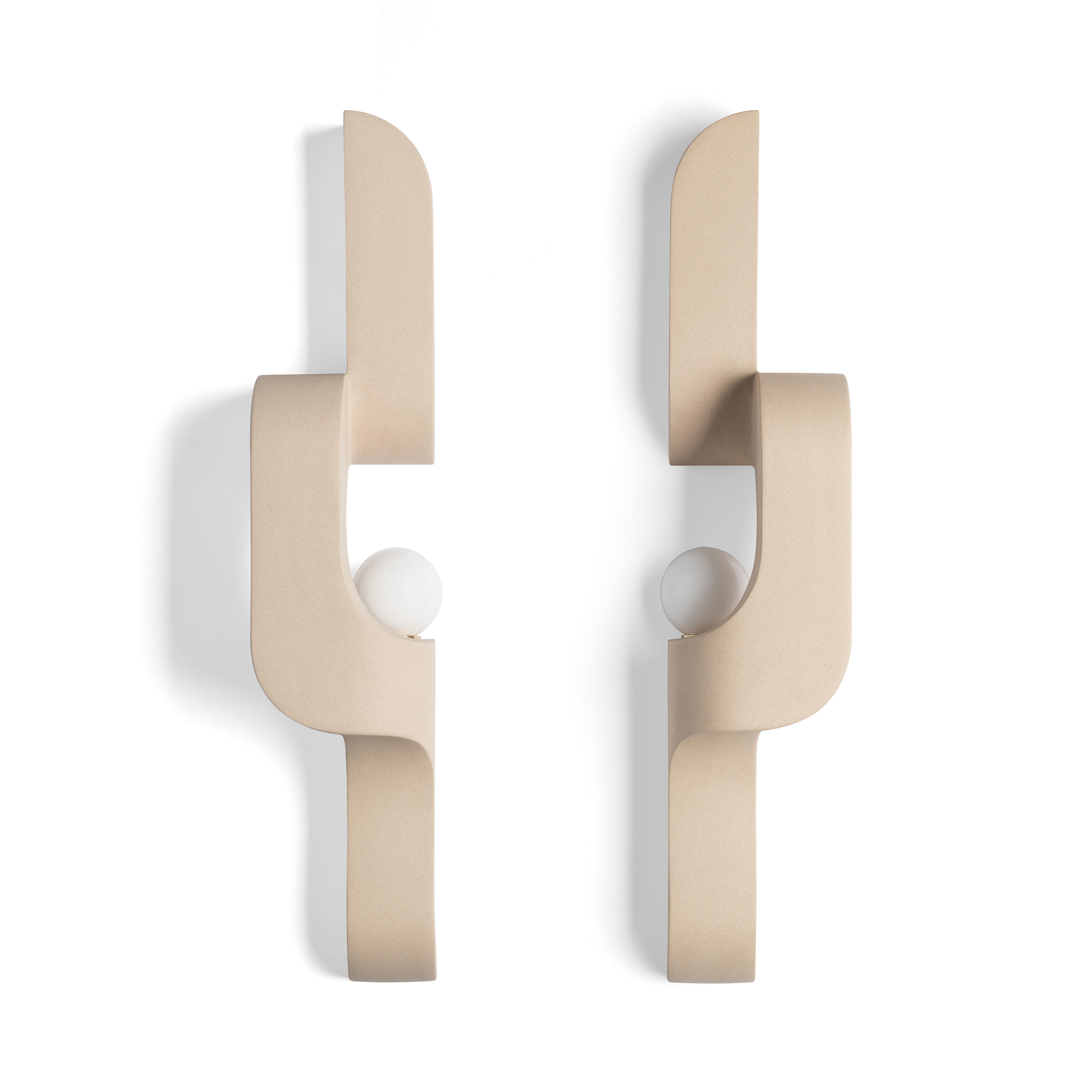 In this ceramic wall sconce, generous curves are paired with crisp edges and the repetition of geometry to create a flow. The sconce snakes up and off the wall, a sculptural lighting piece that's understated, and almost artifact-like. Serpentine is