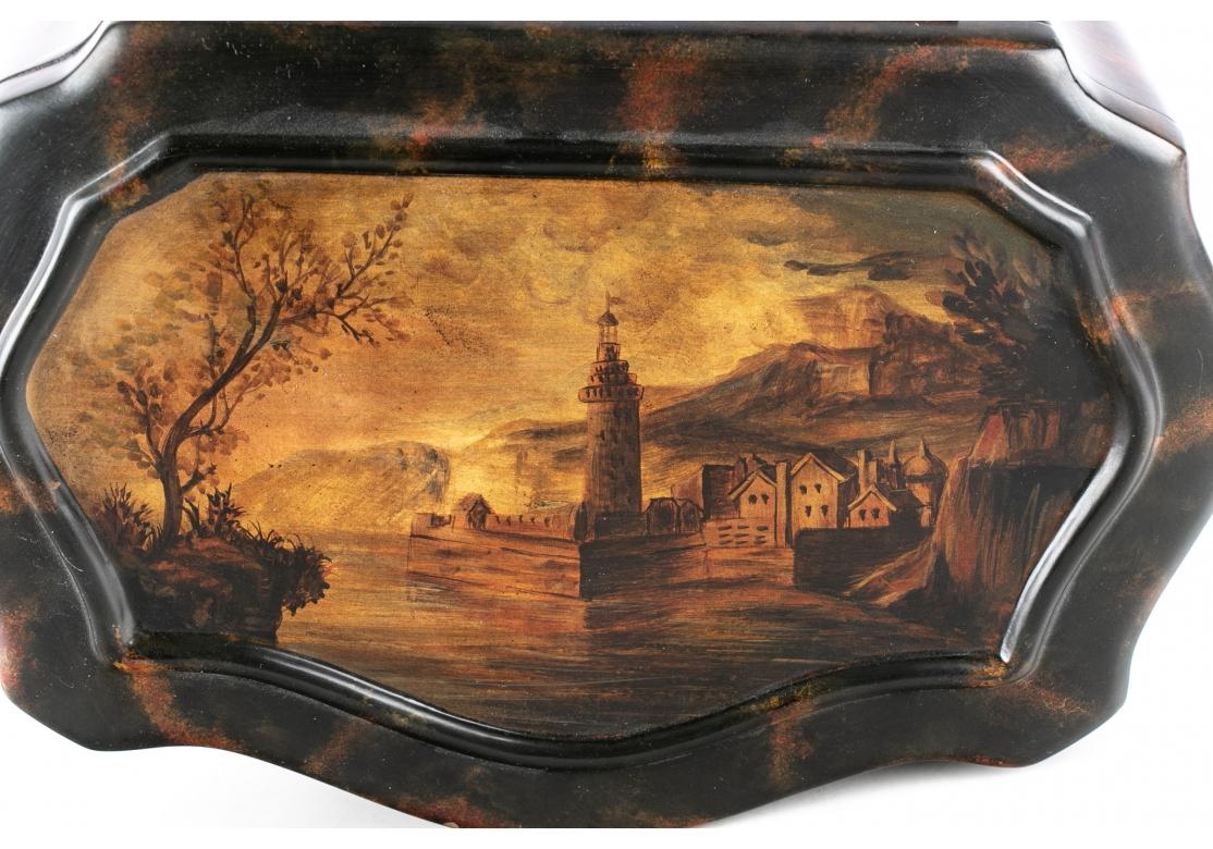 Painted wood with in a faux tortoise finish and suede lined interior and bottom. The hinged lid decorated with a lake landscape with village and tower. 
Measures: 8 x 12