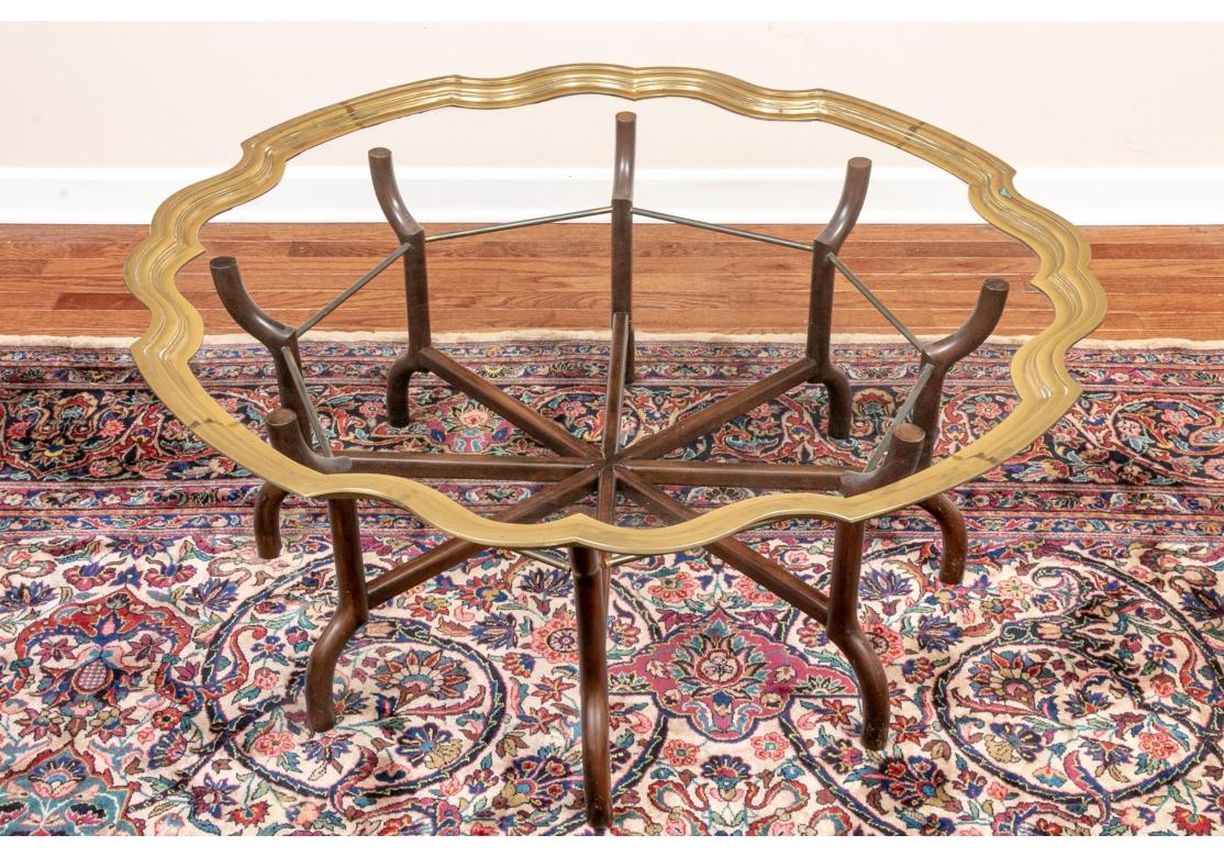 A large and very elegant Cocktail Table in the Hollywood Regency Style. On a fine separate carved wood spider form base with curved legs. 
Diam. 44