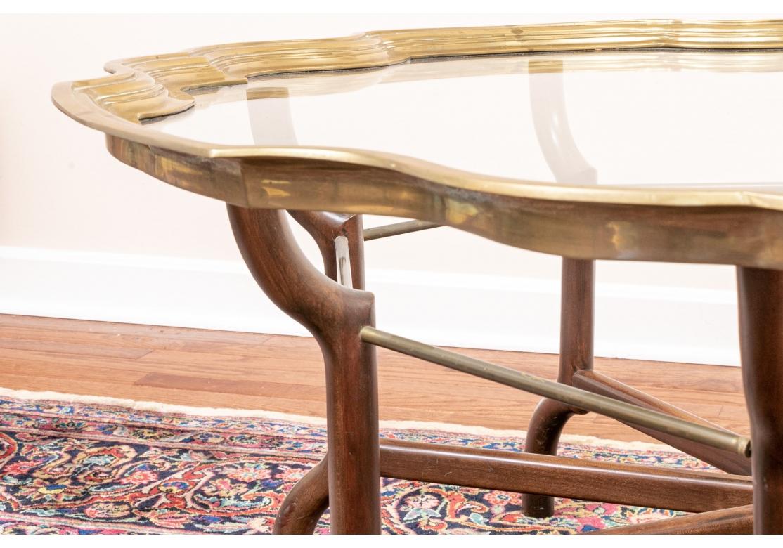 Hollywood Regency Table basse de forme serpentine avec cadre en laiton et plateau en verre en vente