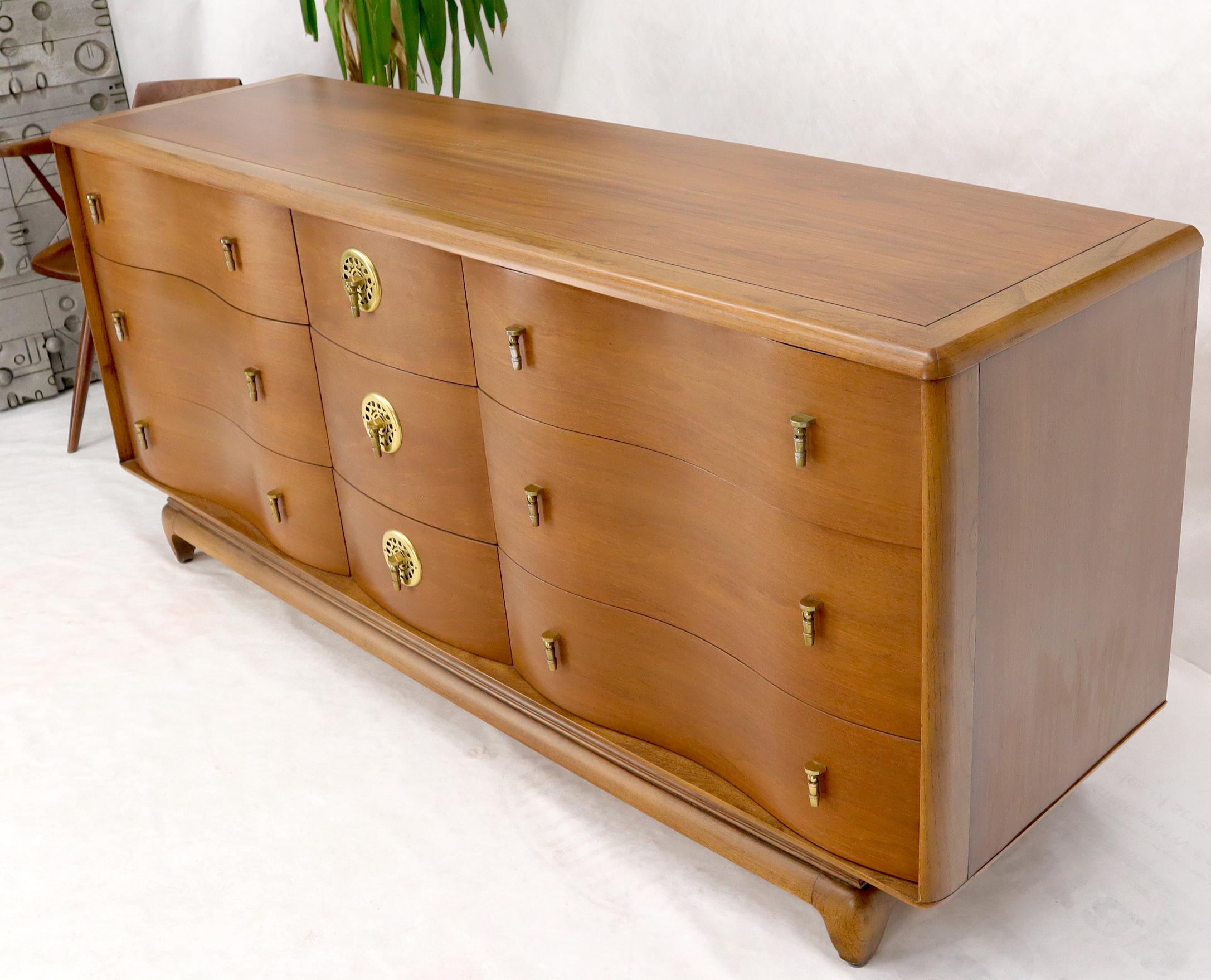 Mid-Century Modern light walnut serpentine front dresser with brass hardware sitting on sculpted tapered legs. Gibbings Parzinger decor style.