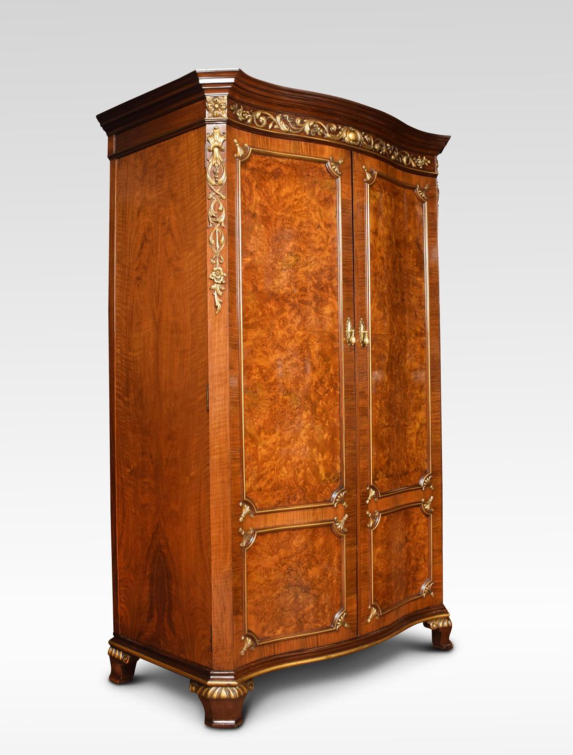 19th century Maple & Co. wardrobe. The flared cornice having giltwood floral scrolling carving above a pair of large serpentine panelled doors opening to reveal cedar wood interior and large hanging area. All raised up on bold bracket