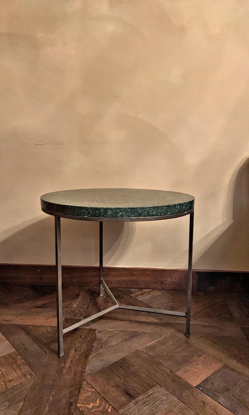 A round occasional table with a 19th century serpentine veneered top on a contemporary base. The top skillfully inlayed with intarsia in a clover decoration the base custom designed by our workshop abd executed in hand forged iron. Finished with a