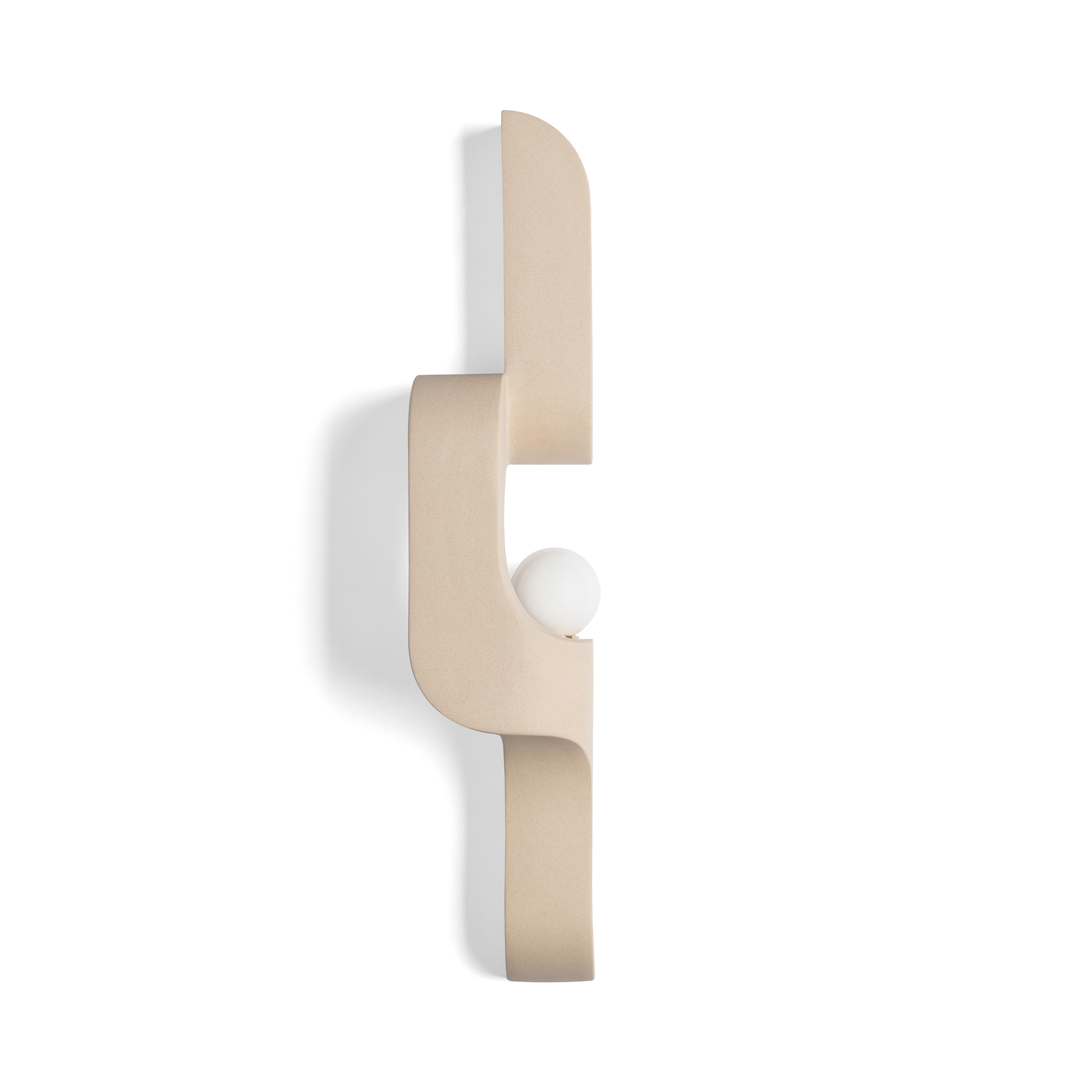 In this ceramic wall sconce, generous curves are paired with crisp edges and the repetition of geometry to create a flow. The sconce snakes up and off the wall, a sculptural lighting piece that's understated, and almost artifact-like.  Serpentine is