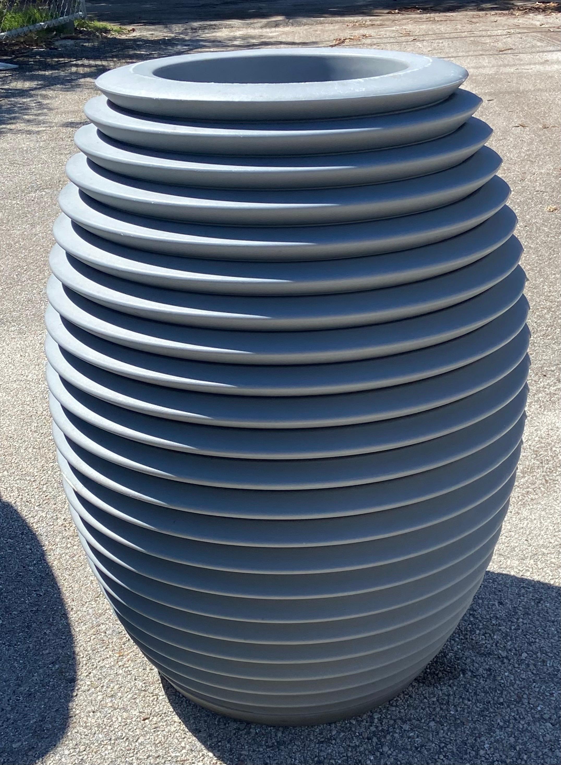 Serralunga Top Pot Hard planter, designed by Ron Arad. 
This large, distinctive planter features a unique, rounded shape with concave circles and is made from linear low-density polyethylene through rotational molding. Made in Italy
It's designed