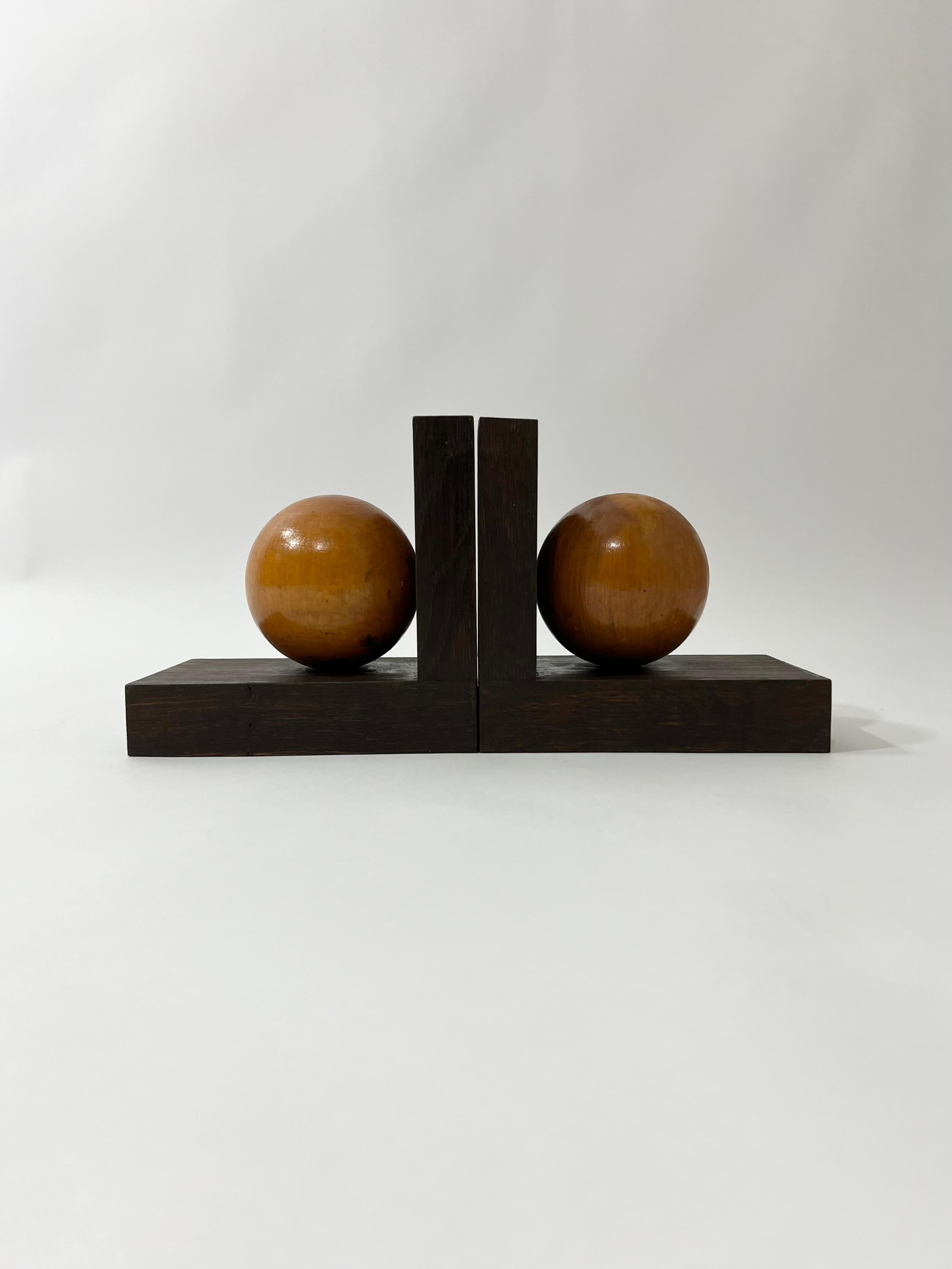 Serre livres art déco dans deux essences de bois massif, France, circa 1930. Traces minimes d'usage conformément à l'âge. Dimensions pour chaque serre livre : longueur 19 cm, hauteur 18 cm, profondeur 12 cm.