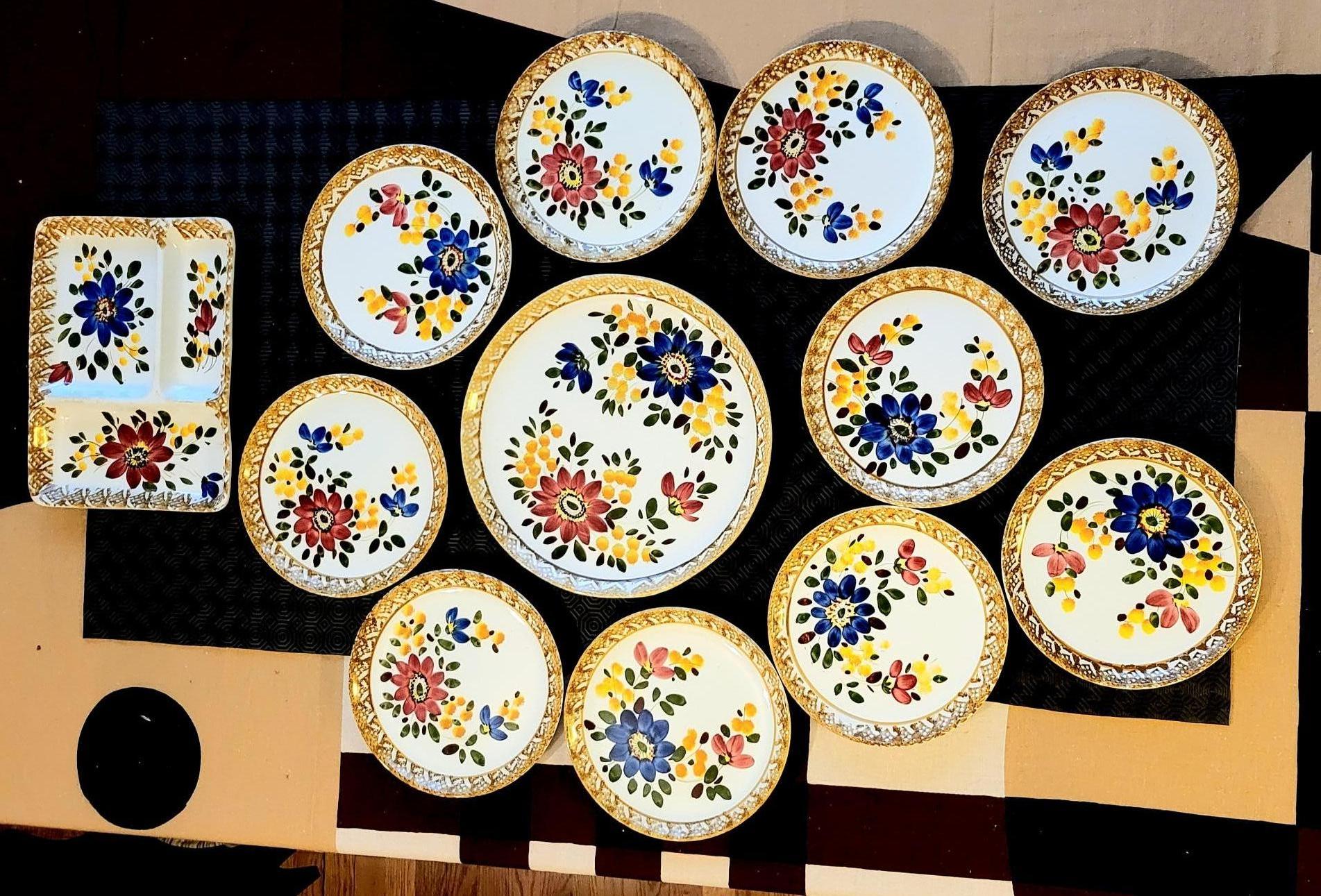 Ce magnifique service datant de l'année 1970, avec un décor floral multicolore, se compose de 10 assiettes plates et de 2 plats de service. Parmi les plats, il y a un plat rectangulaire avec trois compartiments parfait pour présenter une variété de