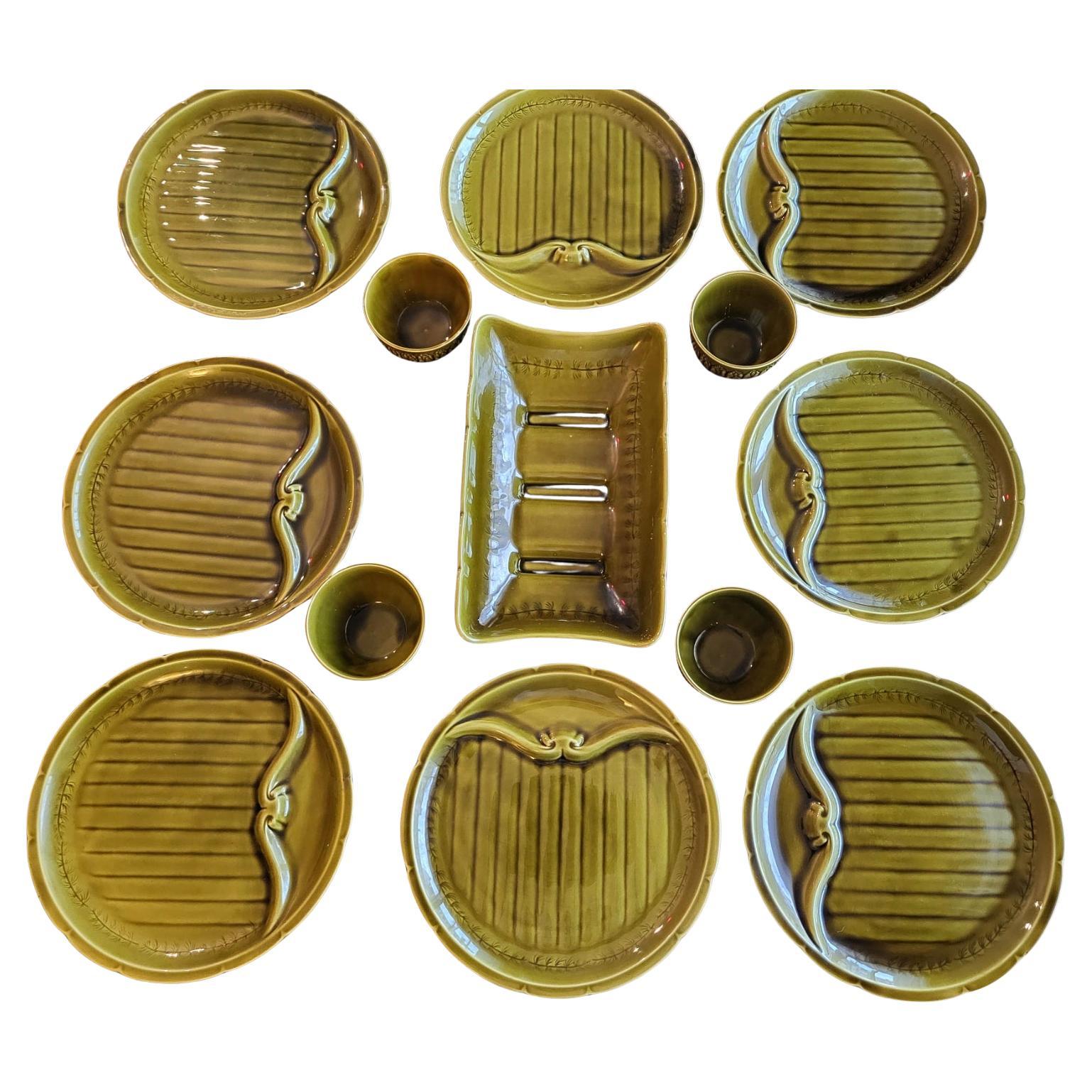 Le service de vaisselle en barbotine faïence Vert Olive Vintage de Gien, France (set de 13) se compose de 8 assiettes compartimentées, spécialement conçues pour accueillir des sauces raffinées, 4 bols élégants et 1 plat de service au design