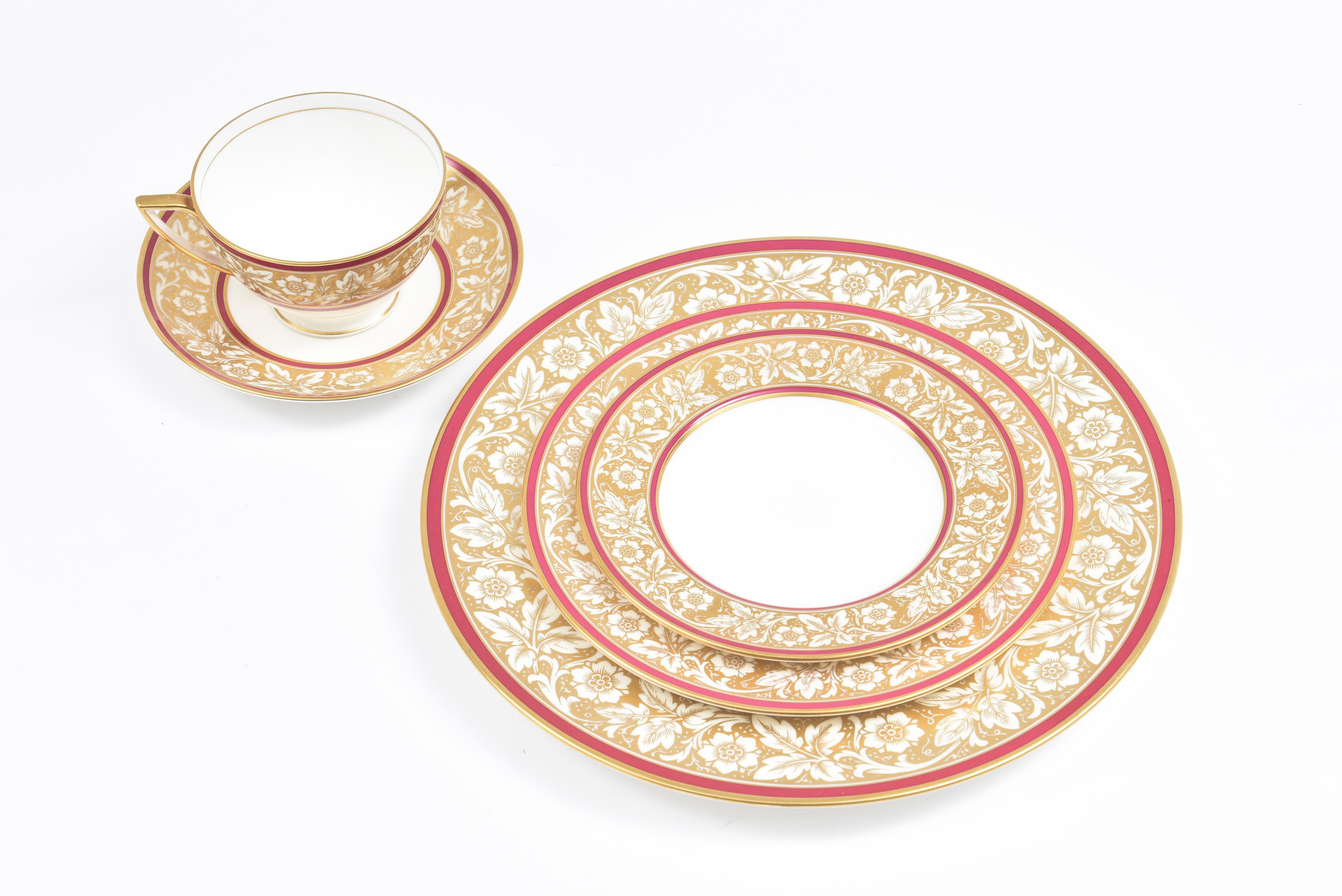 From one of England's premier porcelain factories Minton, this 5 piece place setting has service for 12. Classic and elegant with just a ruby red accent on the collar of the plate and a leaf motif. In very nice vintage condition and ready for your