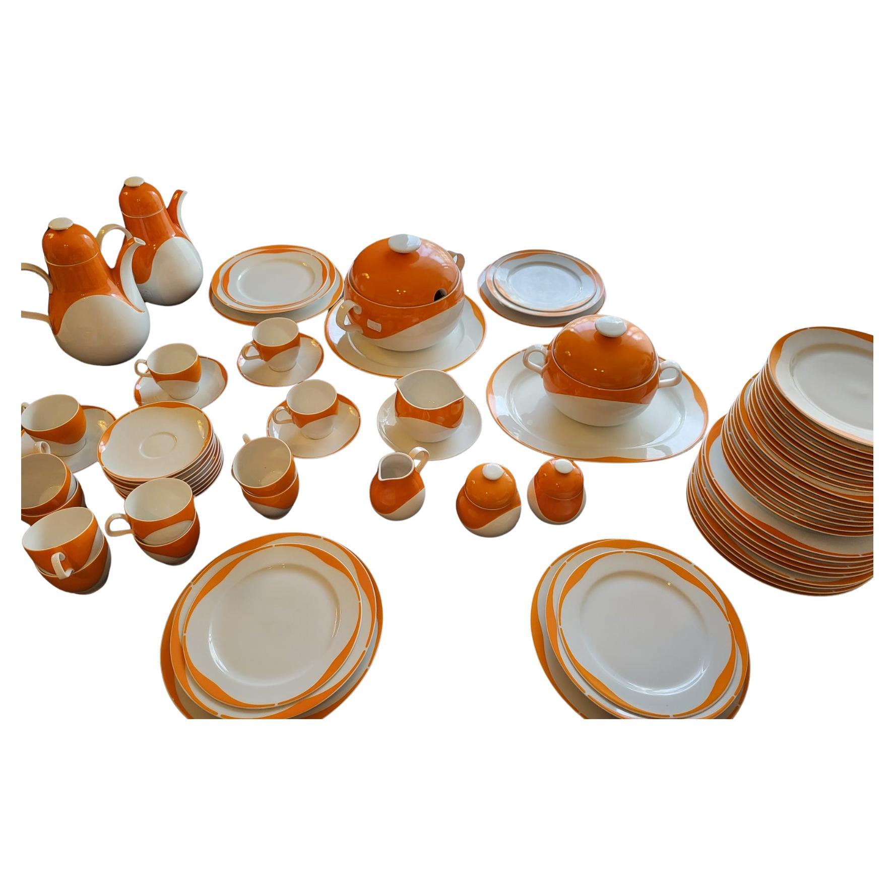 
Service Space Age en porcelaine blanche et orange de 73 pièces. Se compone de: 
13 placas assiettes      12 assiettes creuses    13 assiettes à dessert
1 grand plat de service rond        1 grand plat de service ovale    1 saucière
1 soupière    1