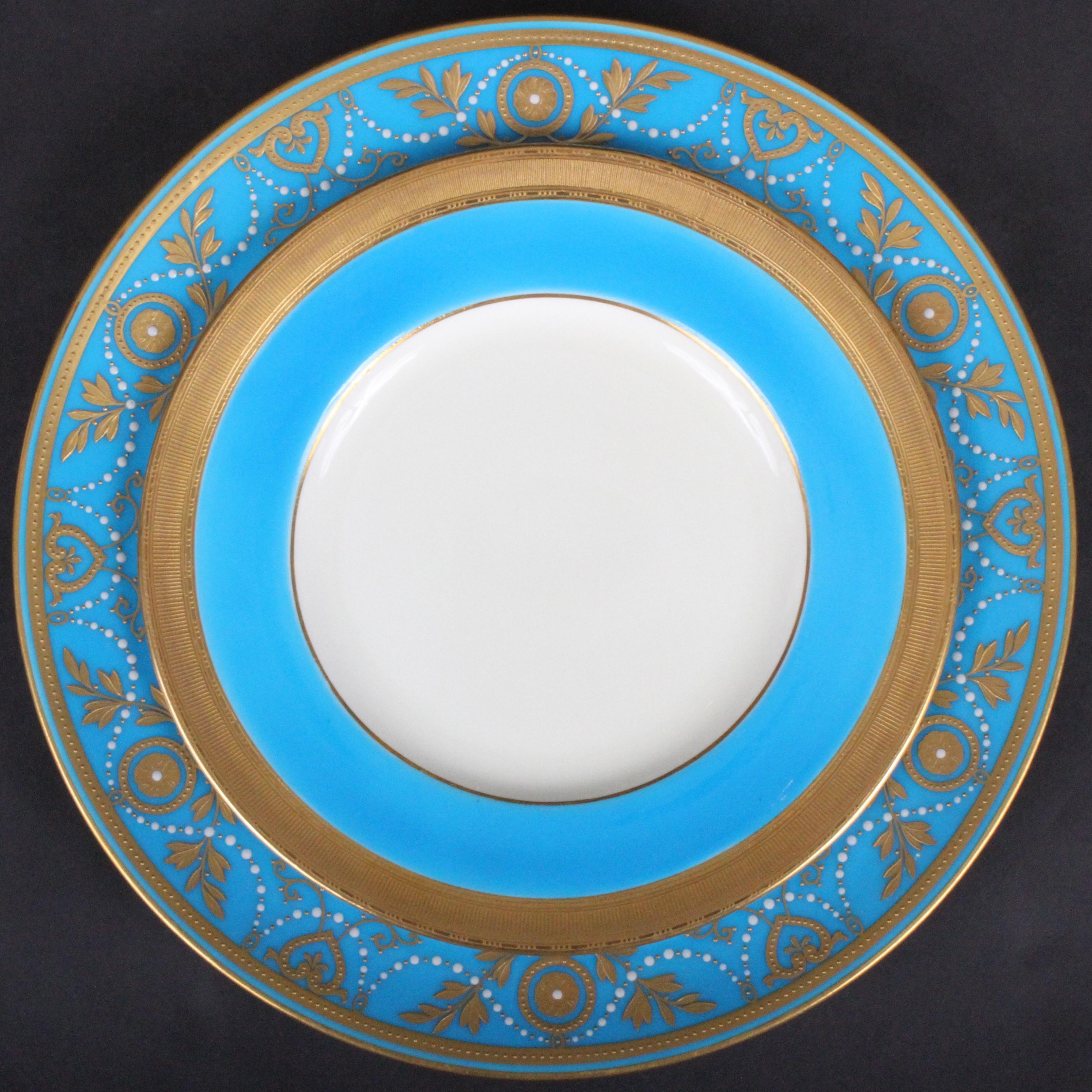 This is a set of 12 monogrammed 22-karat gold encrusted and raised-paste gold turquoise porcelain dinner or service plates, with 12 coordinating turquoise plates. They were made by Minton, Stoke-on-Trent, England. The plates feature Minton’s most
