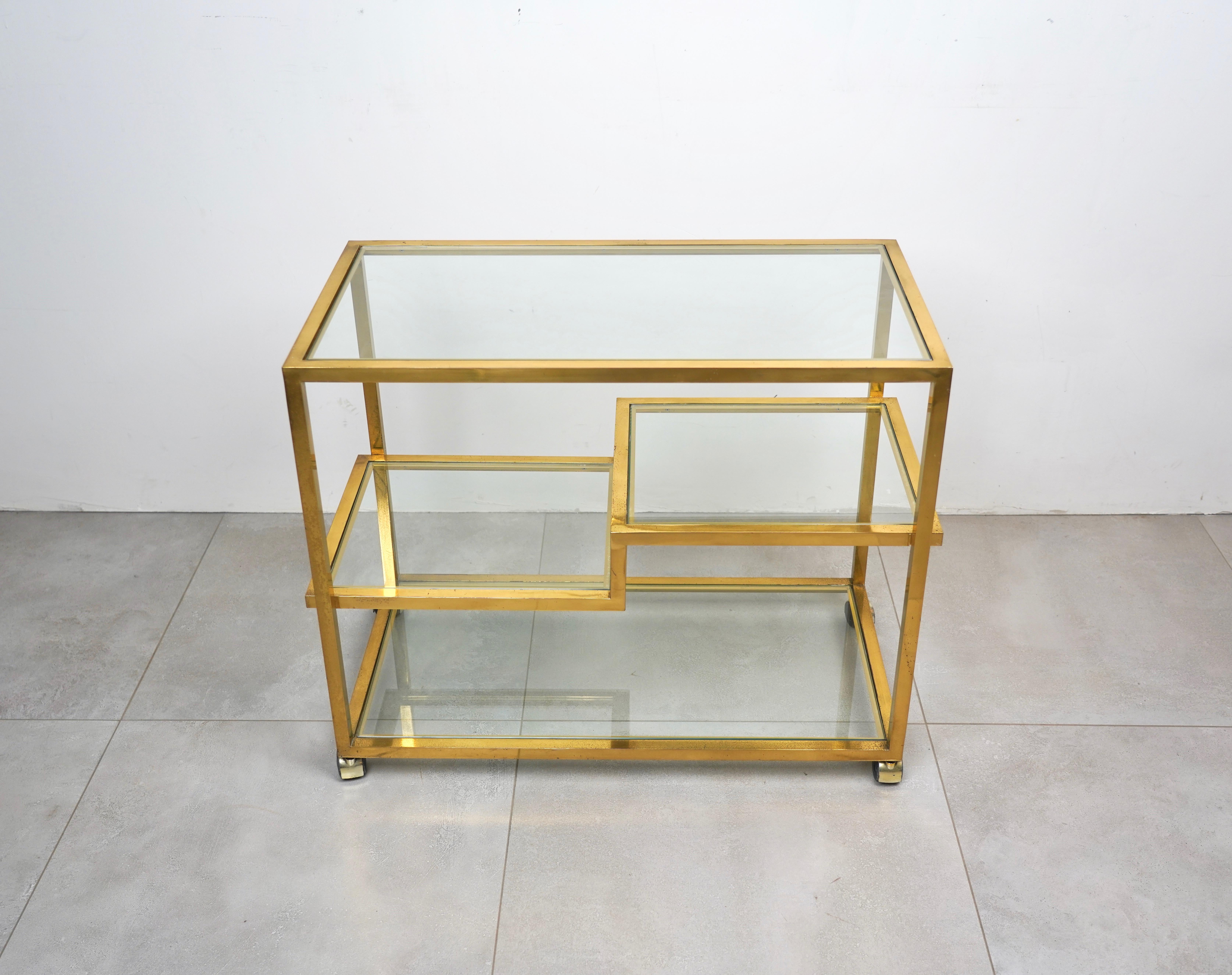 This vintage brass serving cart features unique midcentury design, combining simple lines and plenty of room for storage or service. In the style of to the Italian designer Romeo Rega. Made in Italy in the 1970s.