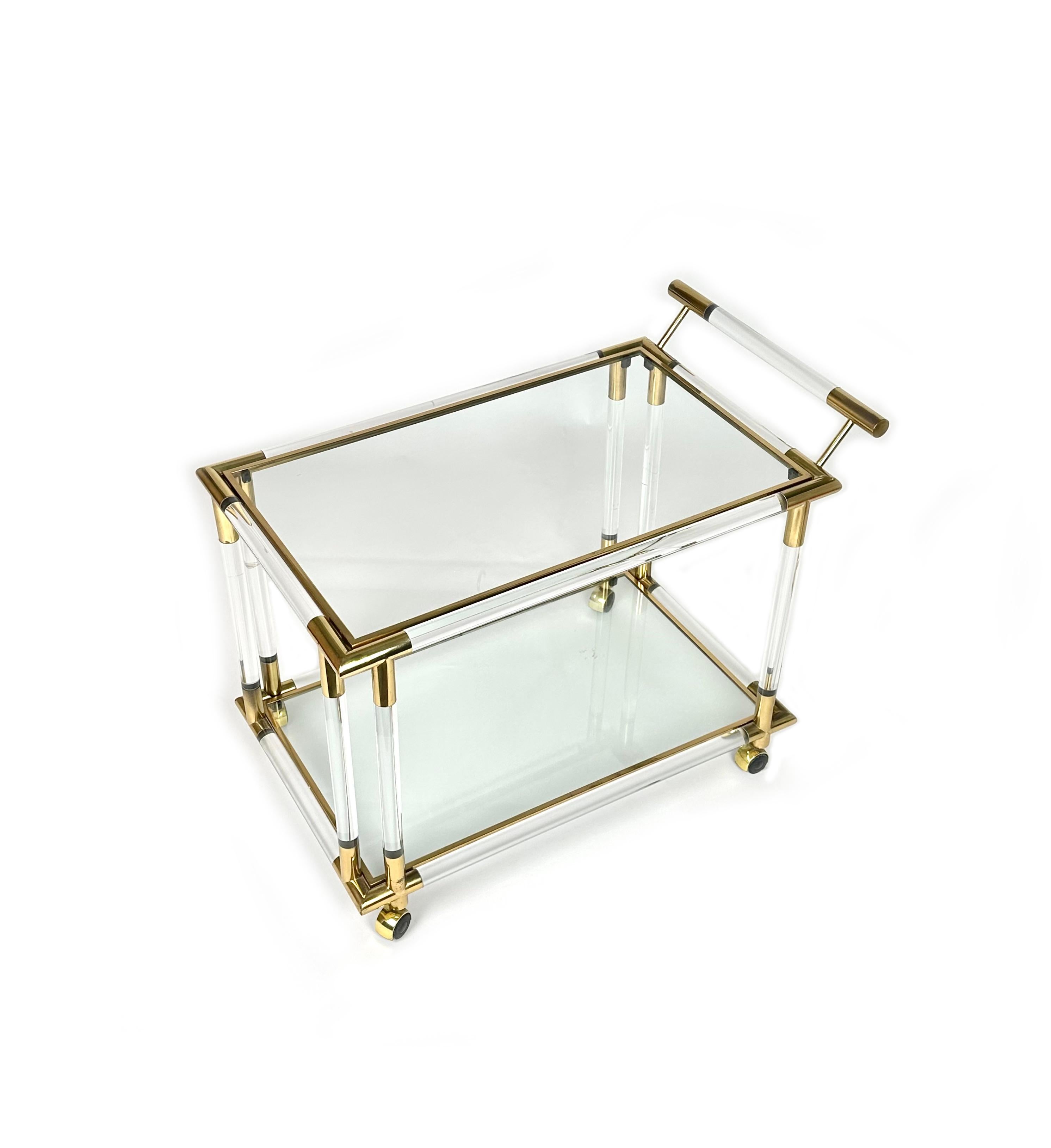 midcentury serving bar cart in the style of Charles Hollis Jones, made in Italy in the 1970s.

This two-tiered serving trolley features solid round tubes of lucite (Acrylic) with polished brass corner trim and handle details as well as two clear