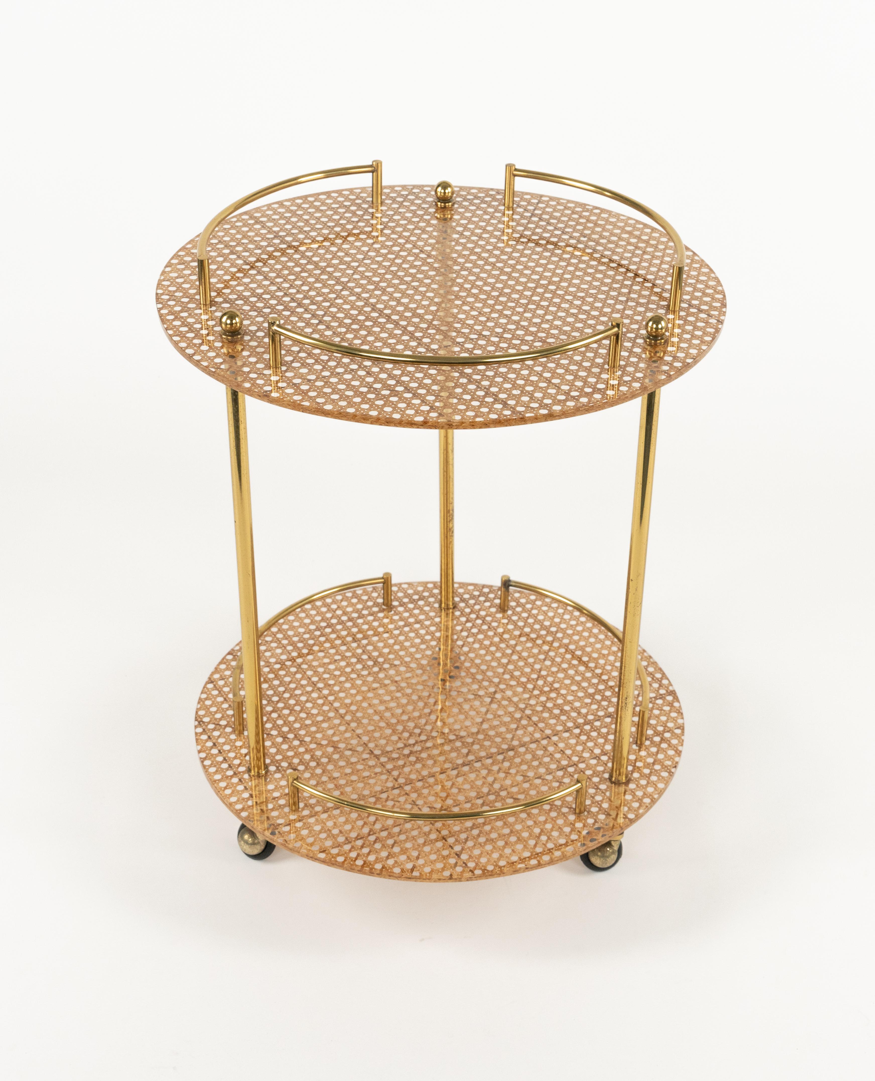 Midcentury amazing round serving bar cart in lucite, brass and rattan in the style of Christian Dior Home.

Made in Italy in the 1970s.